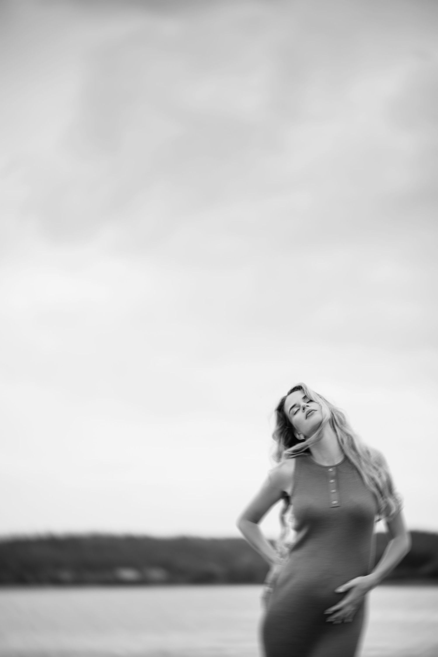 Black and white maternity photos captured against a misty waterfront landscape.