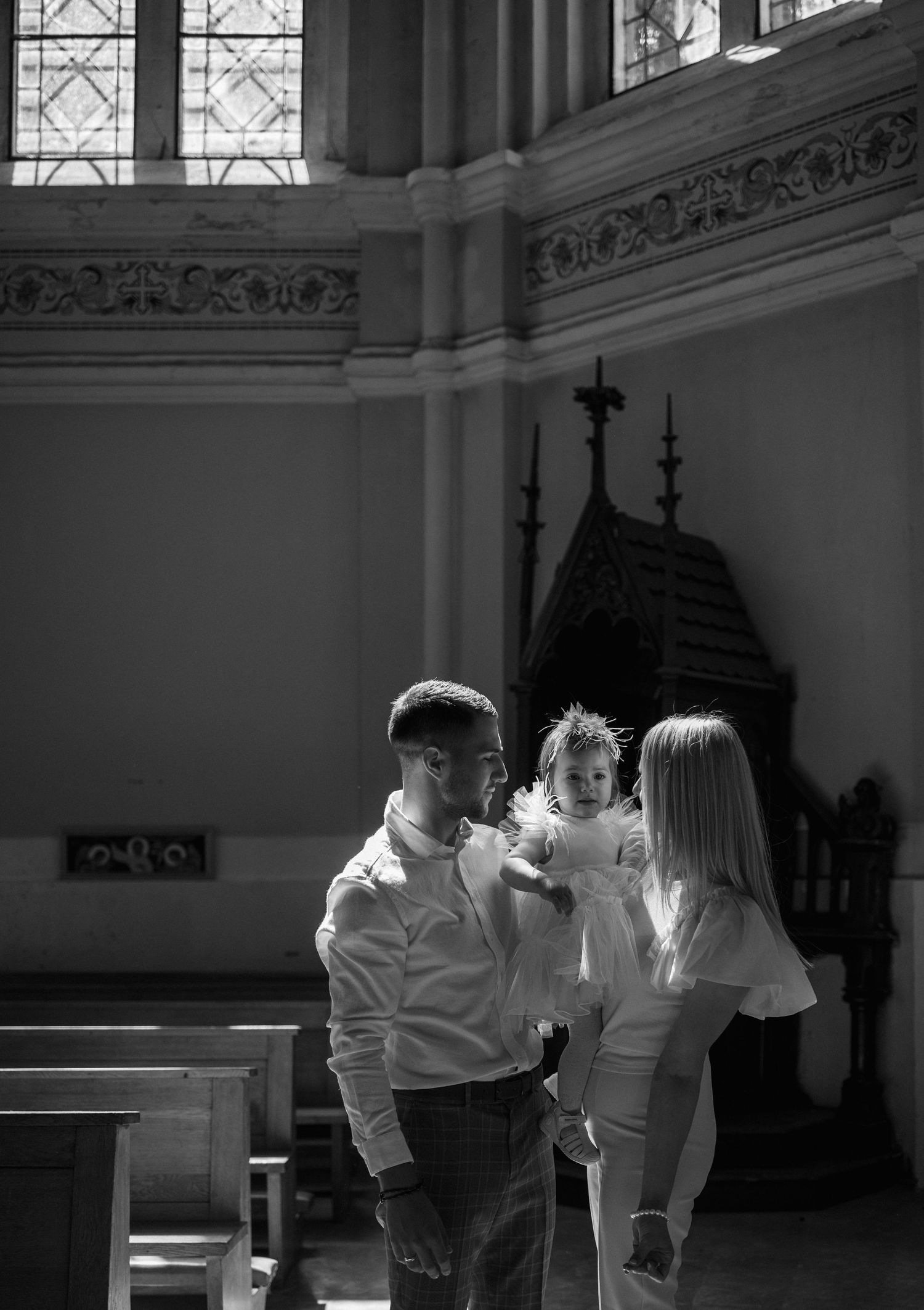 Three figures in white shirts perform a synchronized dance movement inside an ornate church or cathedral interior.