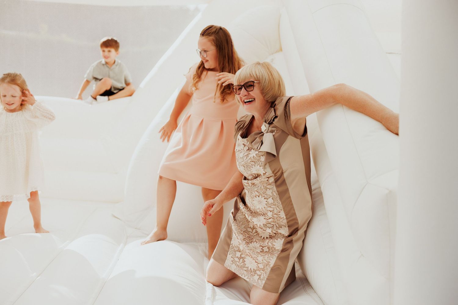 Family gathering in a bright white room wearing coordinated neutral colors.