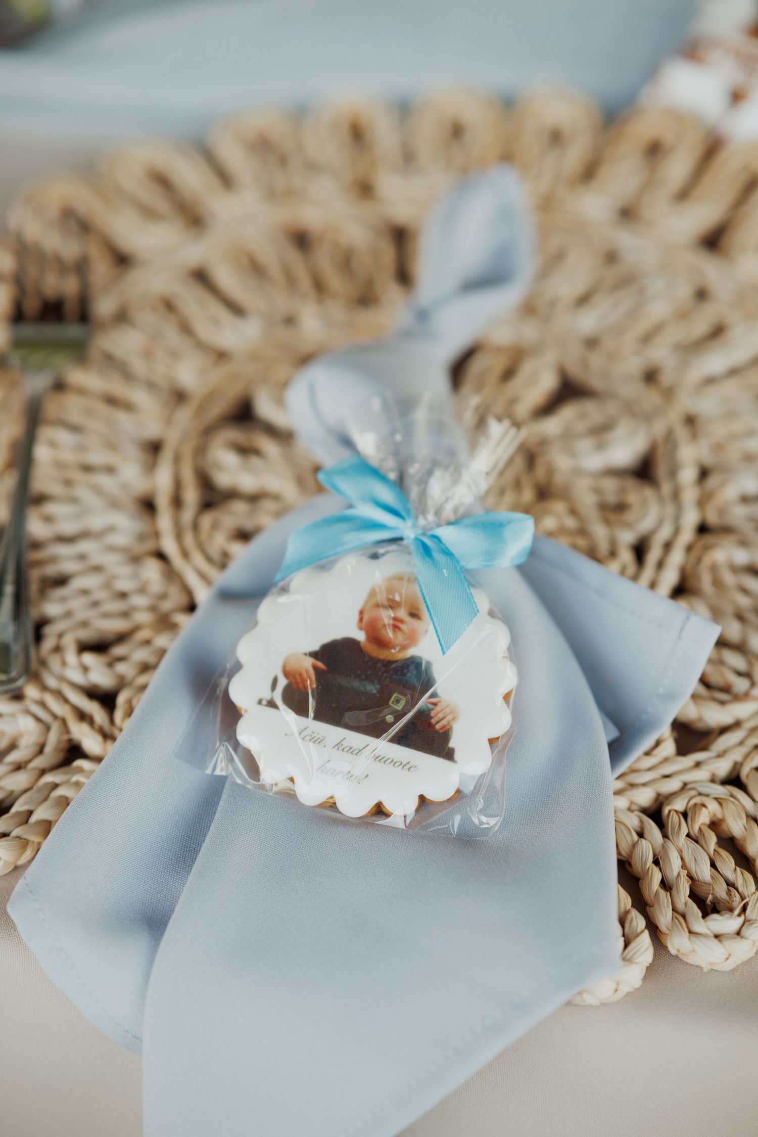 Light blue favor boxes with white lace details and ribbons arranged on a textured gold placemat.