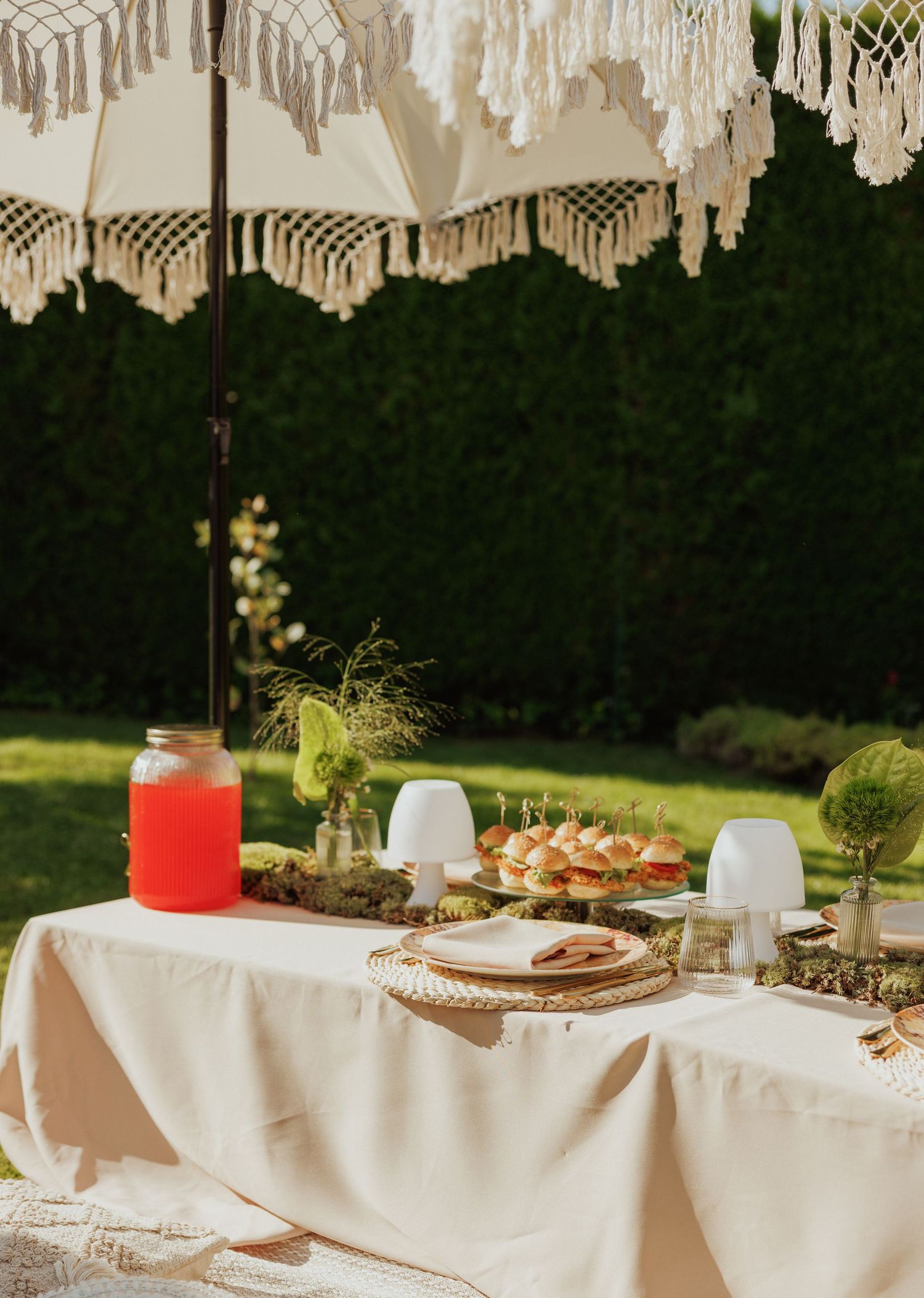 Elegant outdoor table setting with macrame decor and white linens for special occasion.