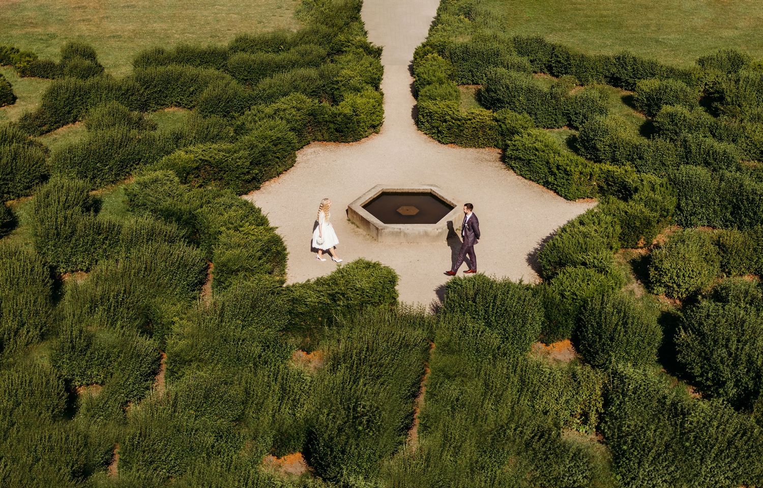 Aerial view of winding garden paths through lush green landscaping with scattered benches and walkways.