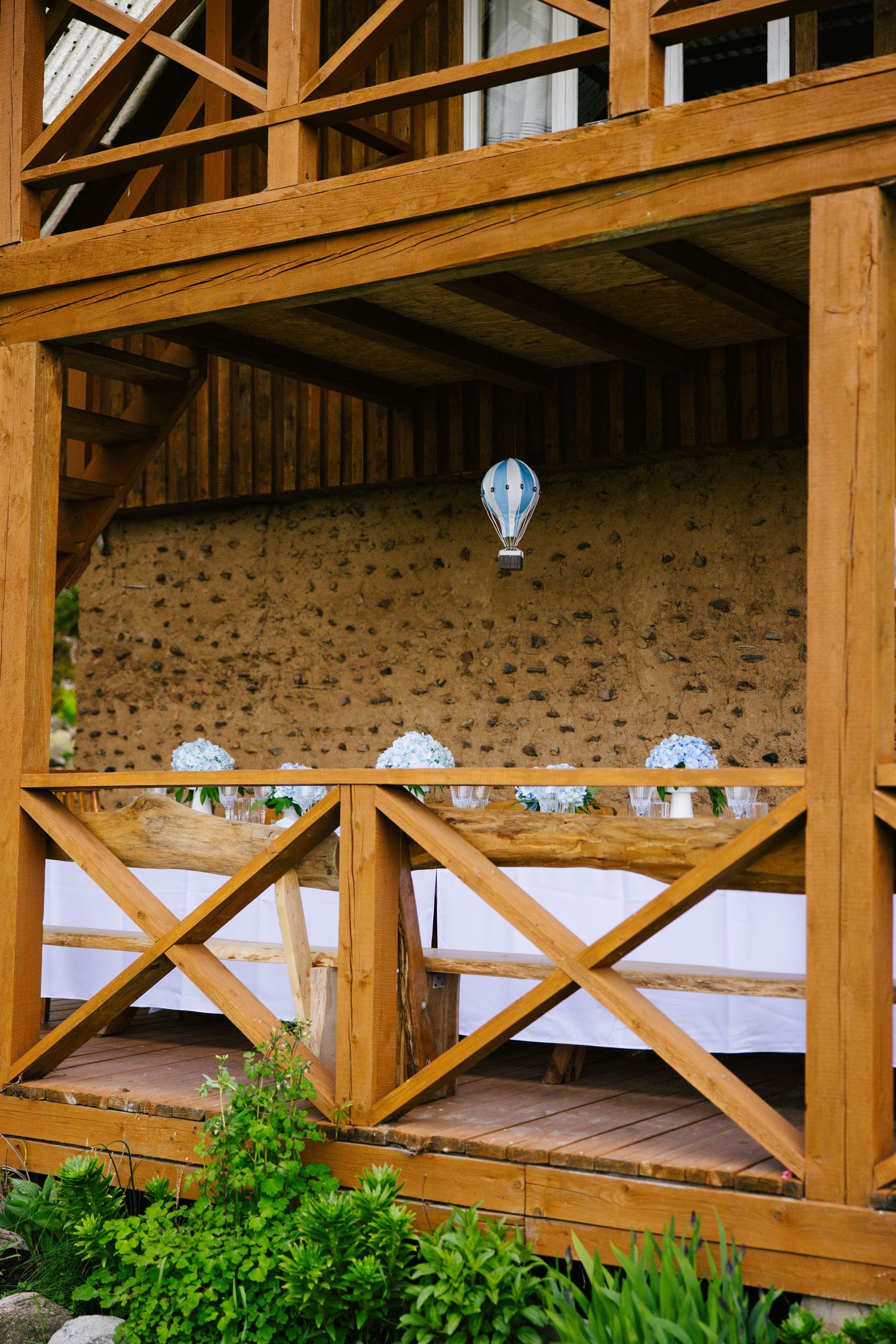 Rustic wooden pavilion with exposed beams and stone walls.