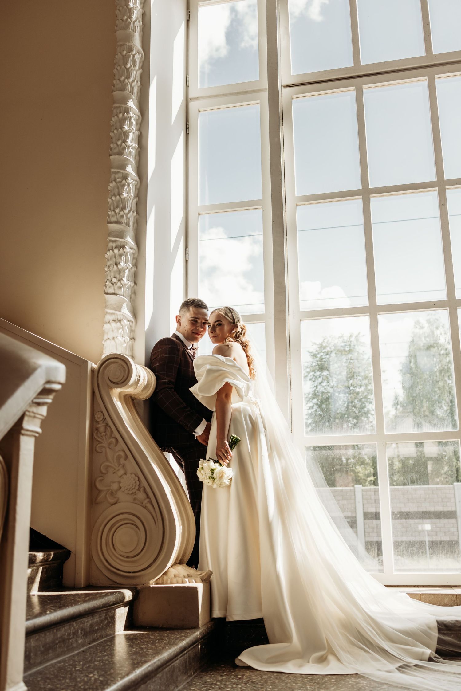 Sunlit staircase with ornate architectural details in an elegant wedding venue.