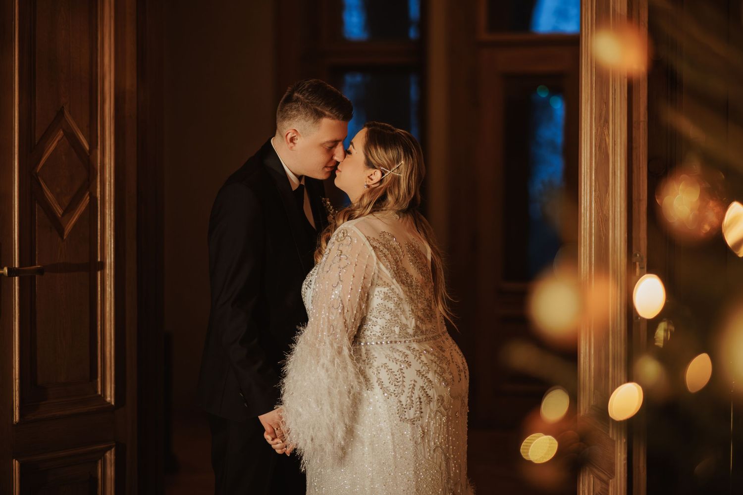 Intimate wedding portraits captured in warm lighting against wooden architectural details.