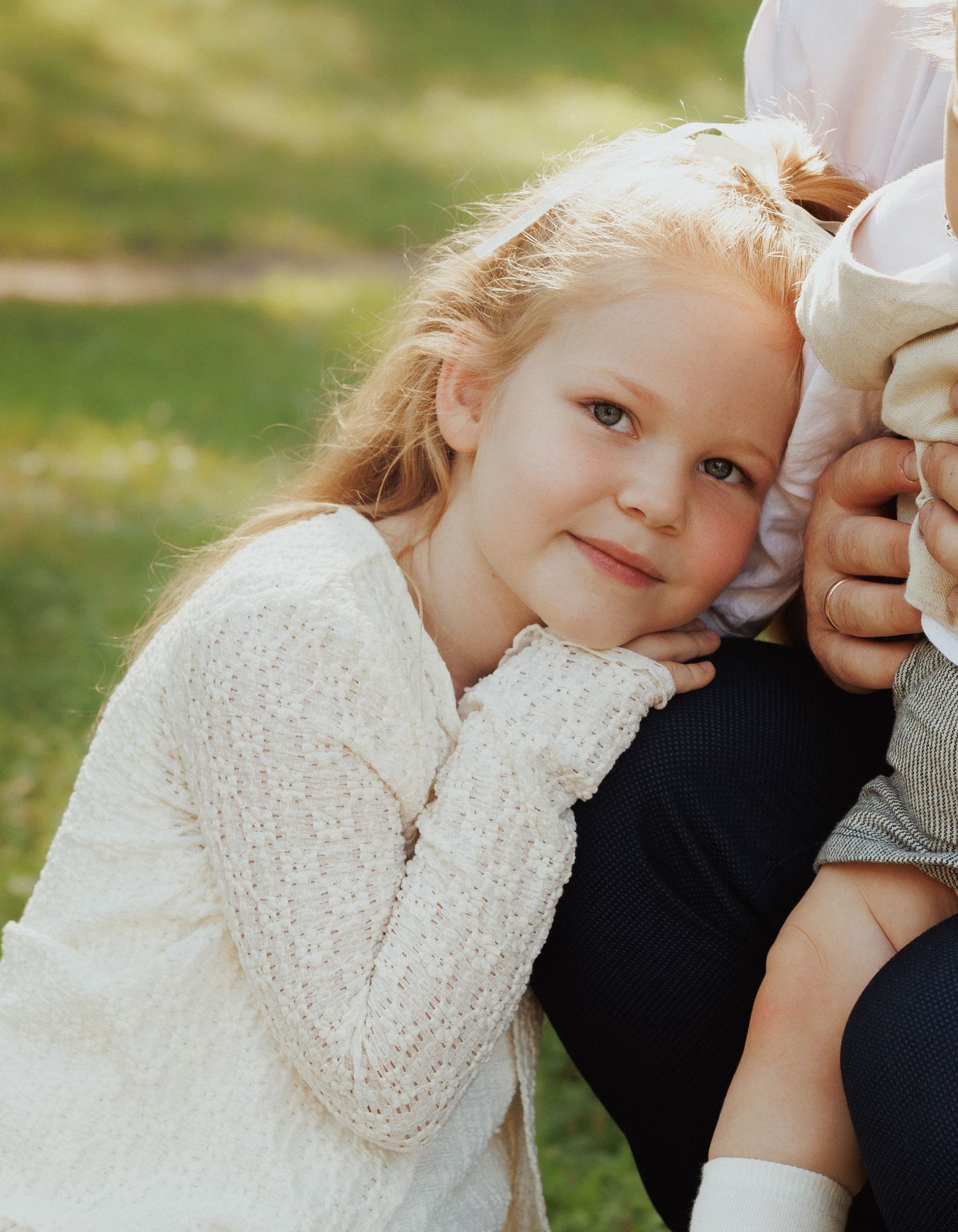 A series of candid close-up shots showing tender moments between a child and adult in natural outdoor lighting.