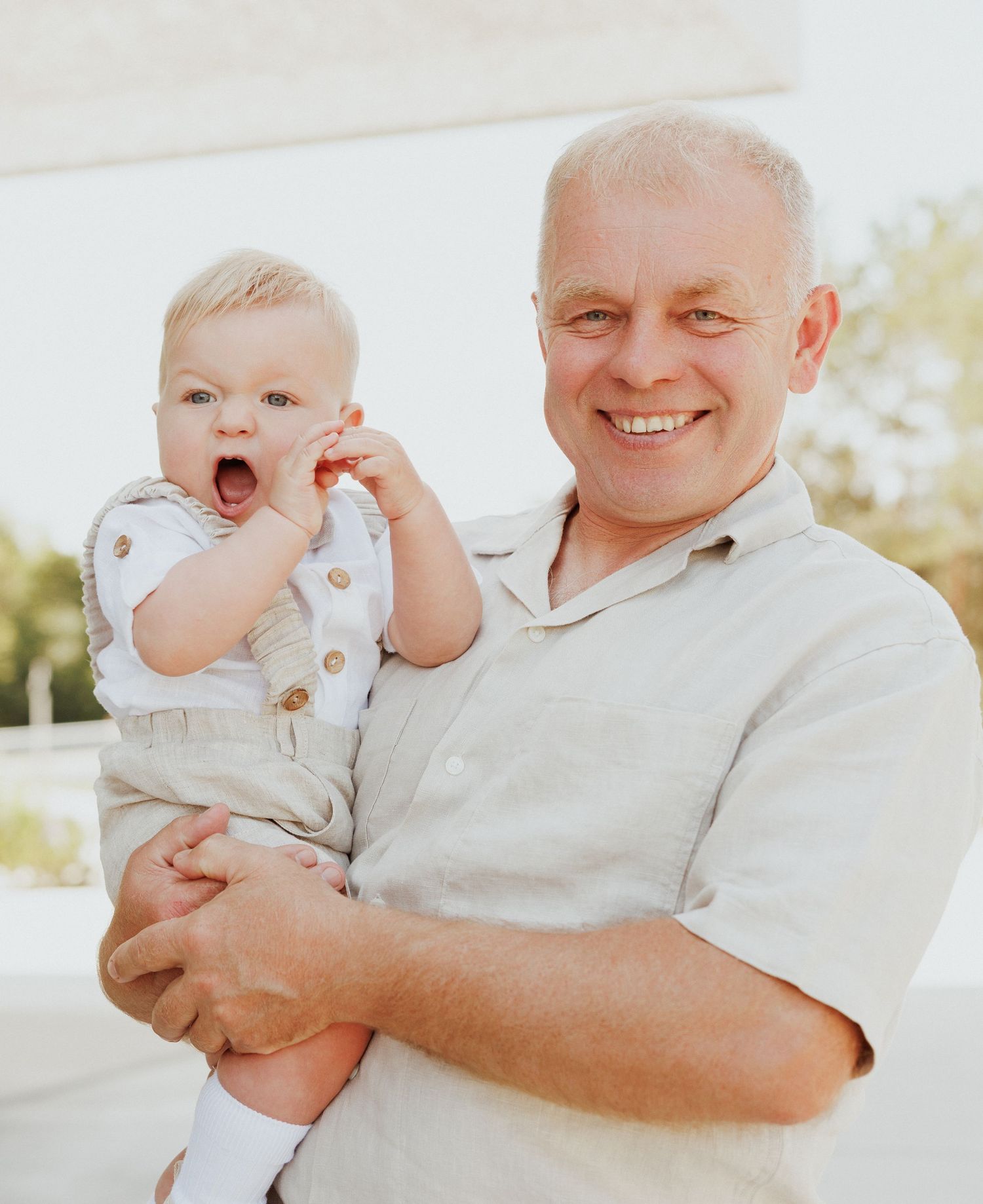 Candid moments of joy between family members dressed in white outdoors.