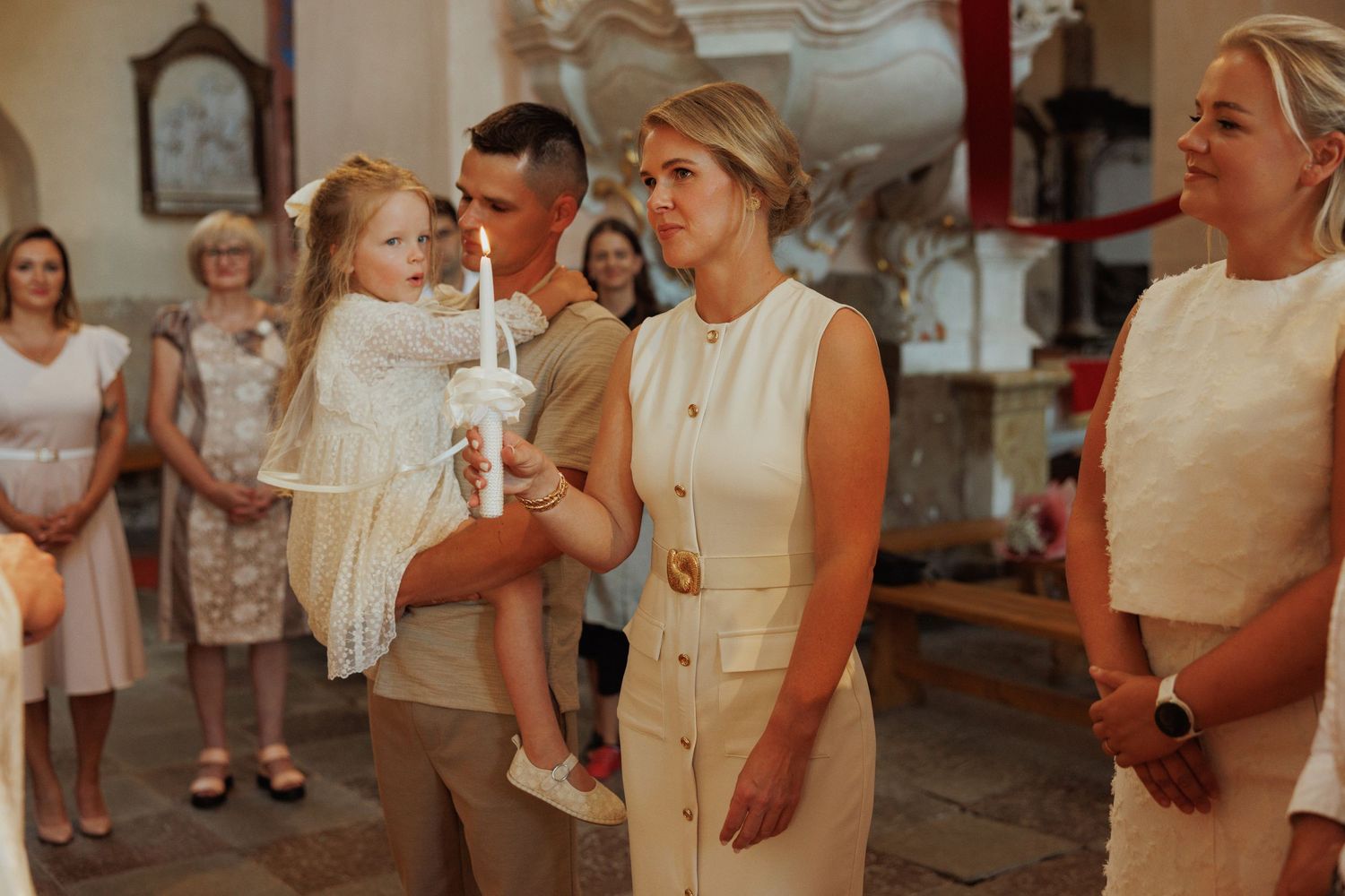 A group of people in cream-colored formal attire gather together for a special occasion or event.