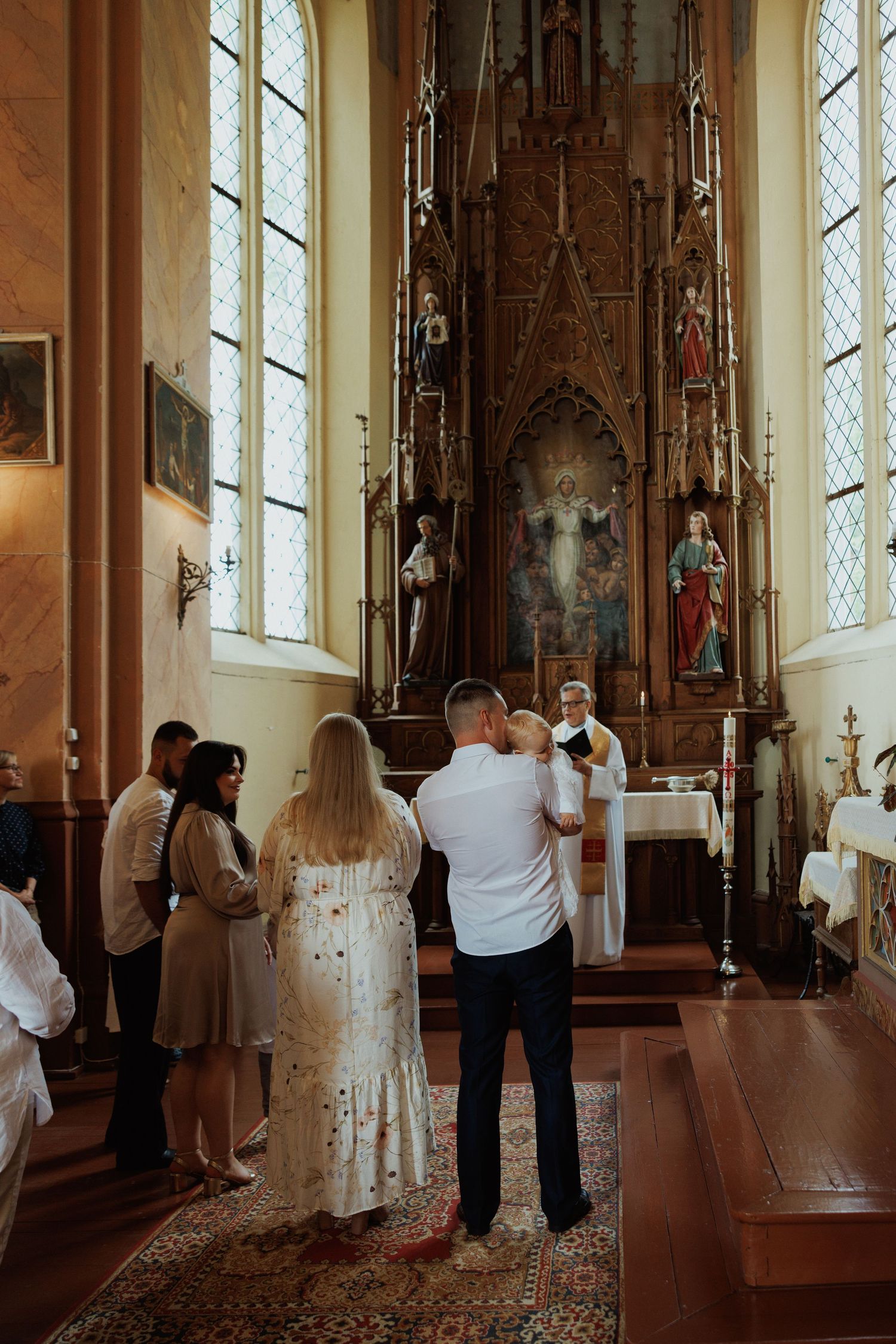 Wedding ceremony in a traditional church with gothic altar and stained glass windows.