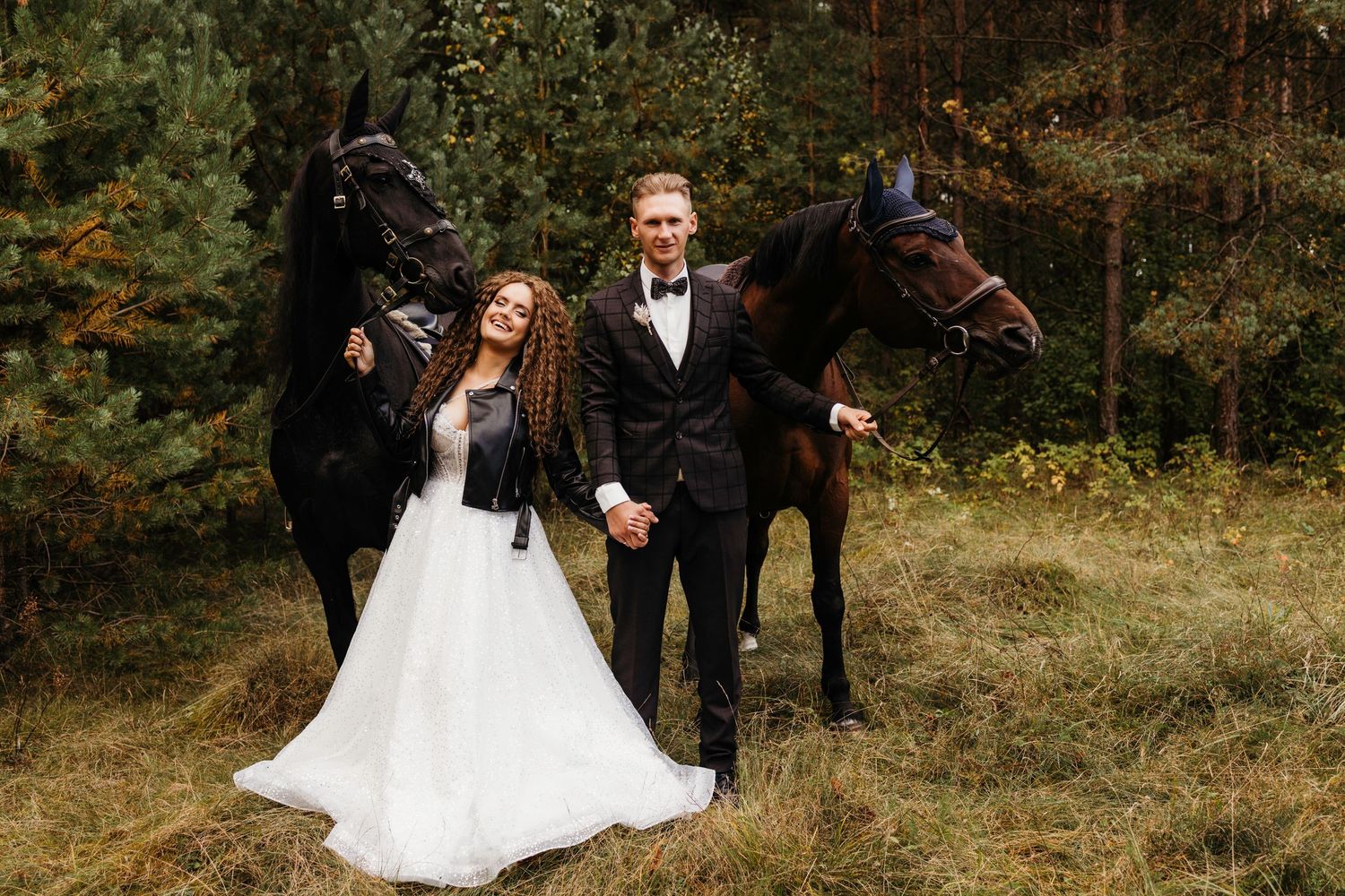 Wedding couple poses with their horse in a rustic autumn field setting.