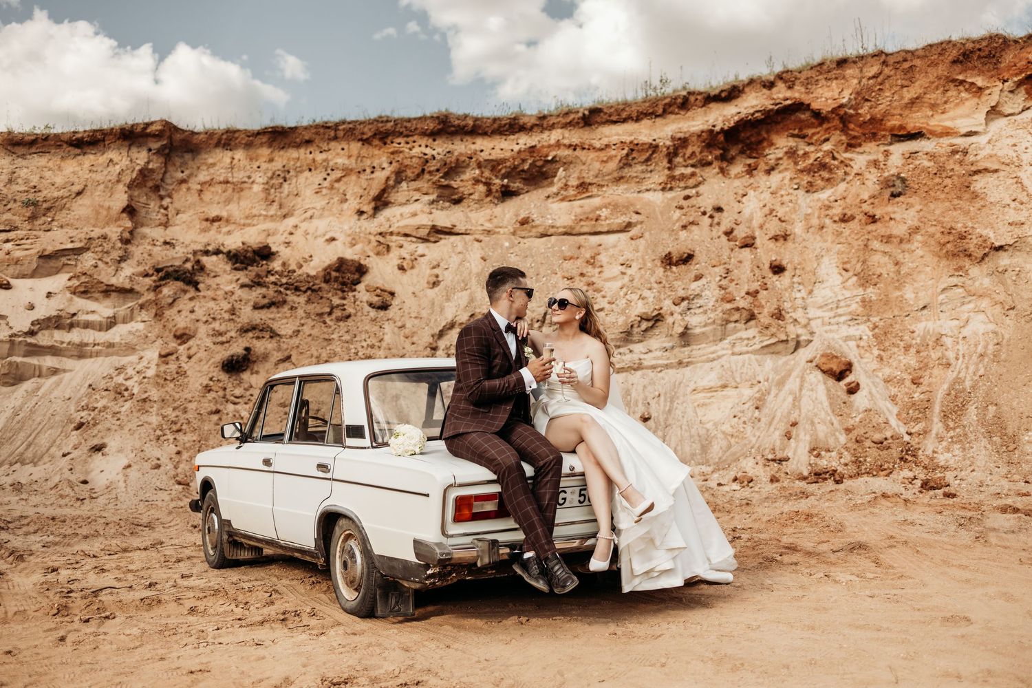 A panoramic wedding photo series showing a couple with a classic car against red rock cliffs.