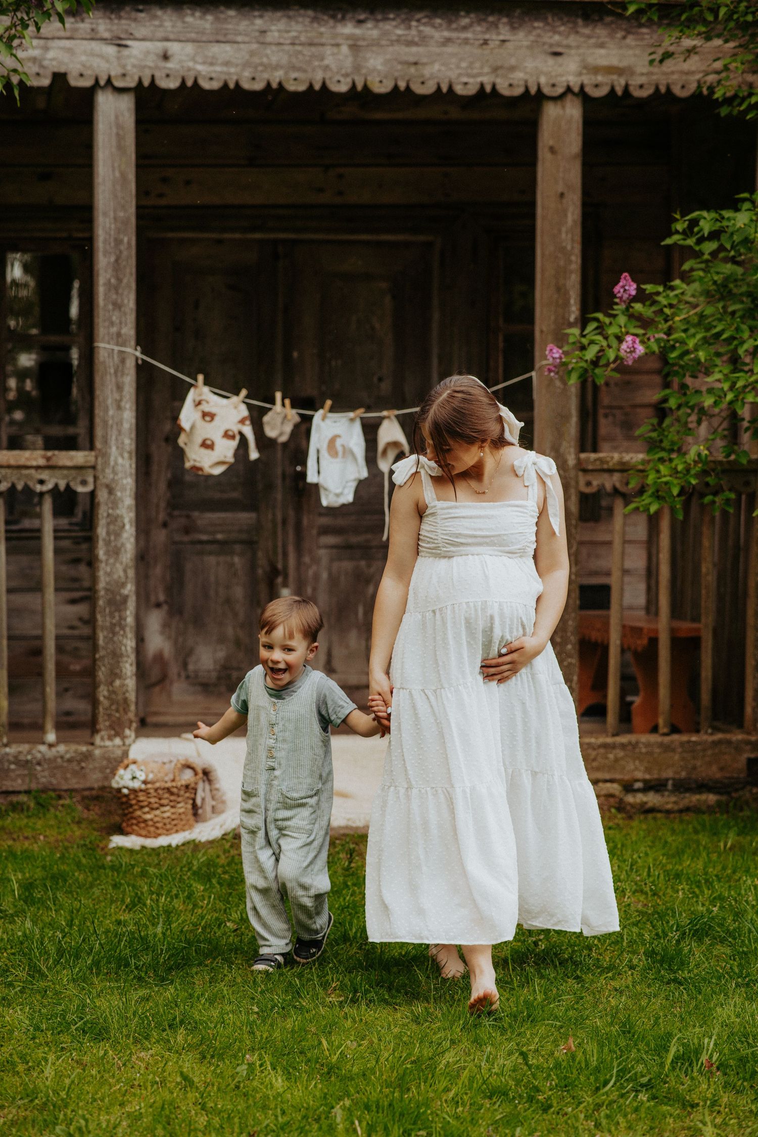 A playful scene in a garden with white dresses hanging on a clothesline near a rustic wooden building.