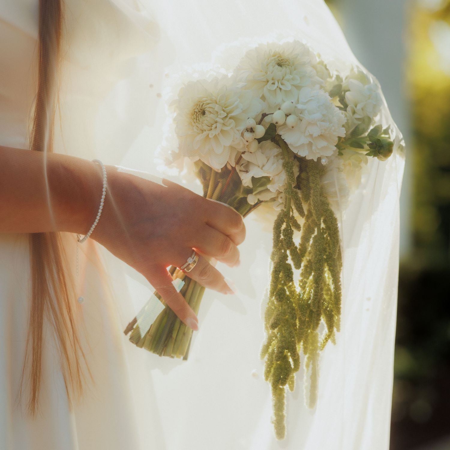 Close-up detail of white wedding bouquet with delicate flowers.
