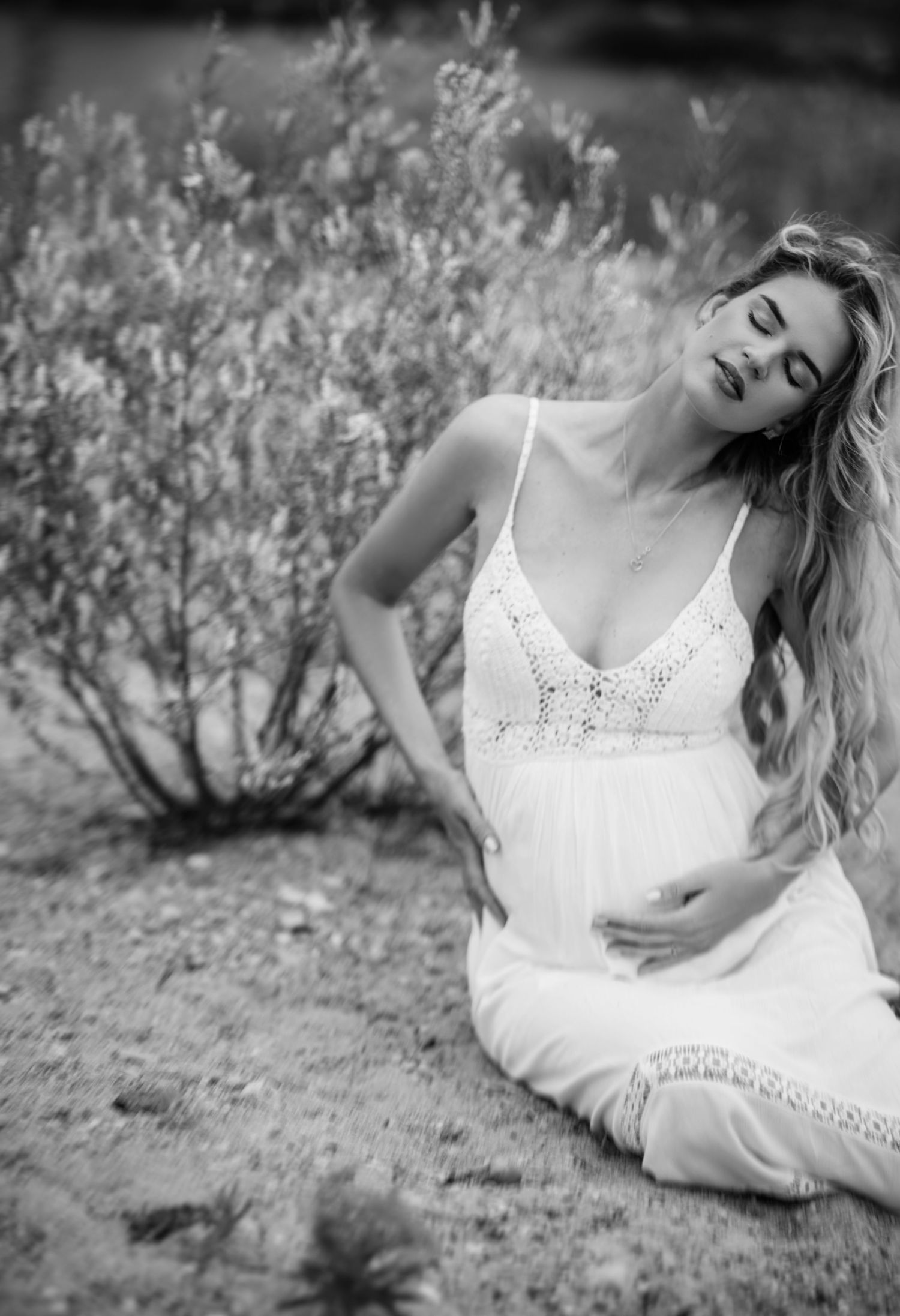 Black and white artistic portraits of a woman lying in natural surroundings.