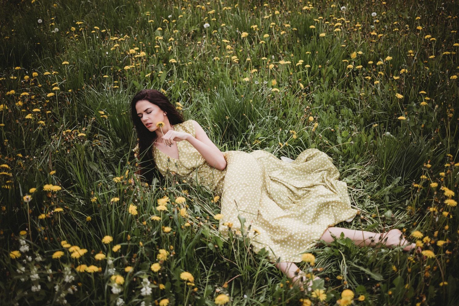 Romantic portrait series in vintage dress amid blooming spring meadow.