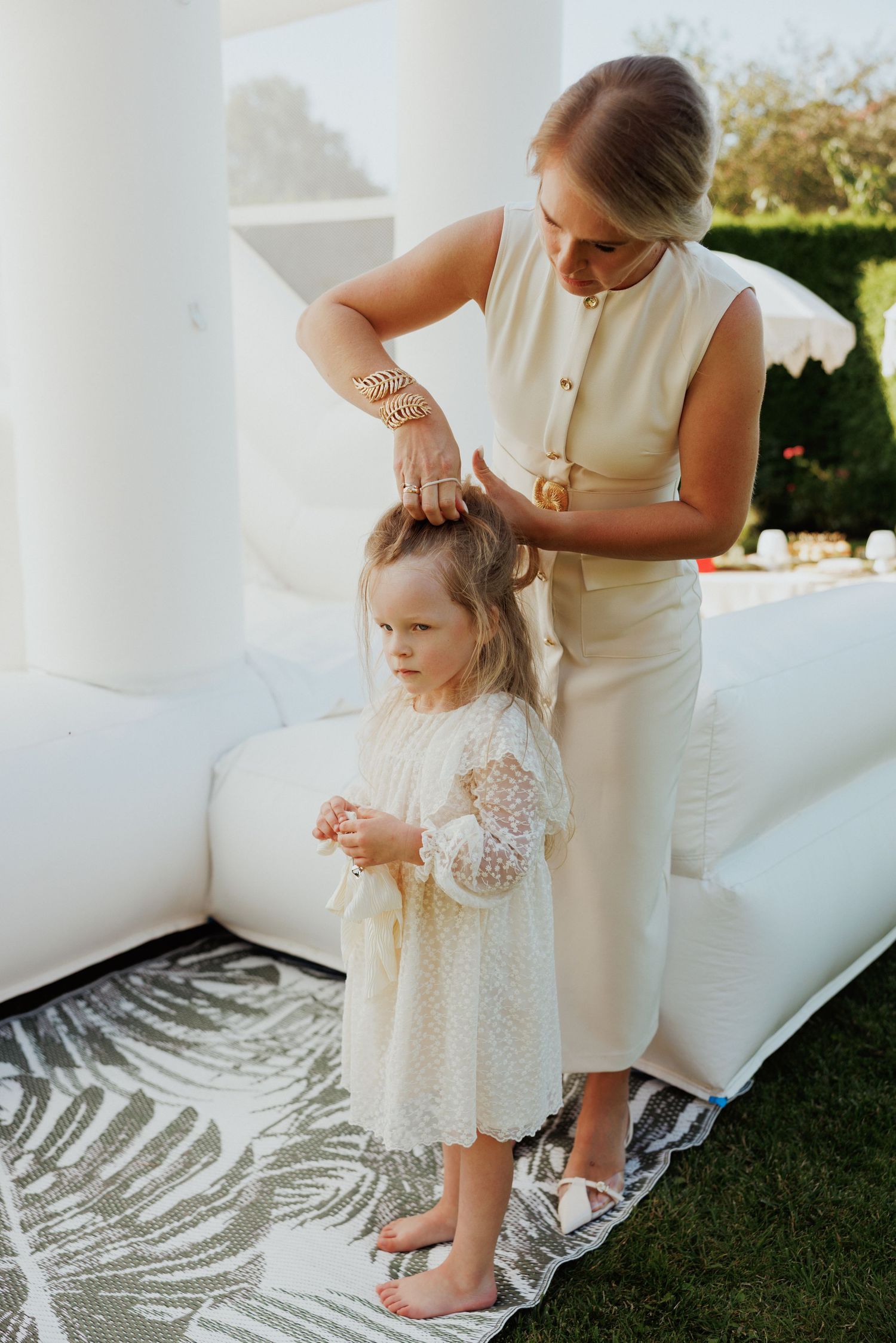 Tender moment captured on a white outdoor couch with lace dress details.