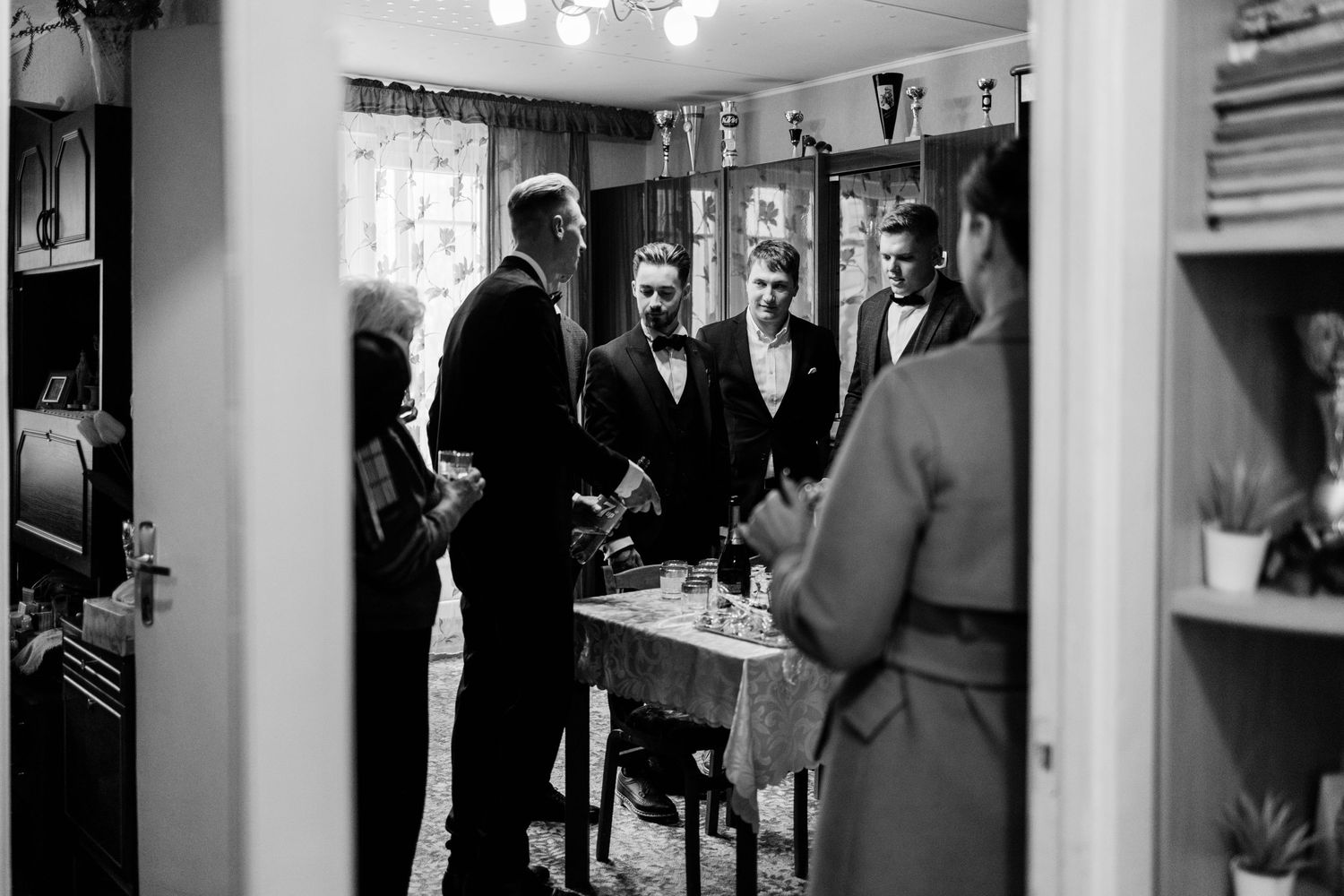 Black and white photo series showing intimate moments between a couple in an indoor setting.