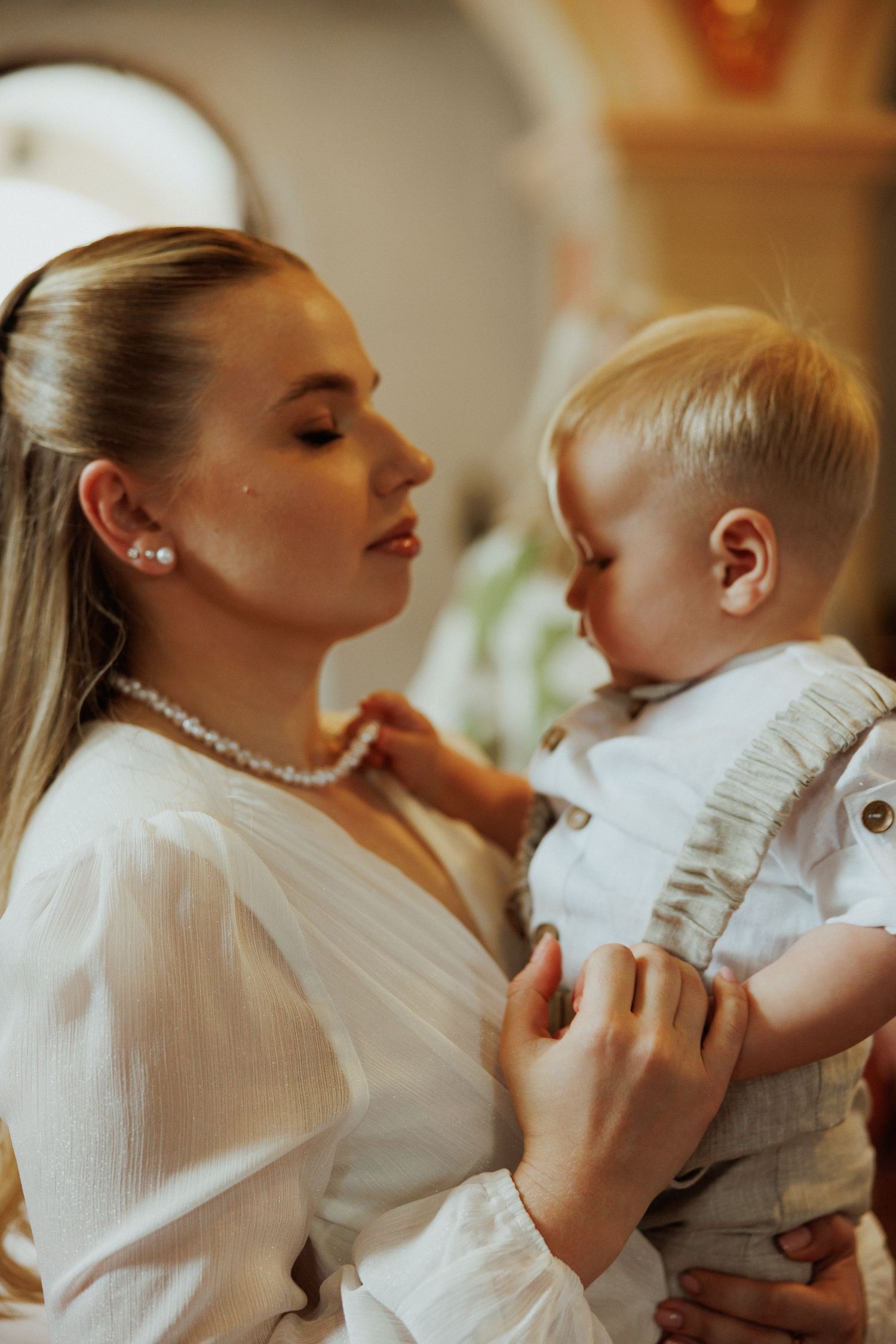 Intimate series of photos showing a parent and infant sharing sweet moments in white attire.