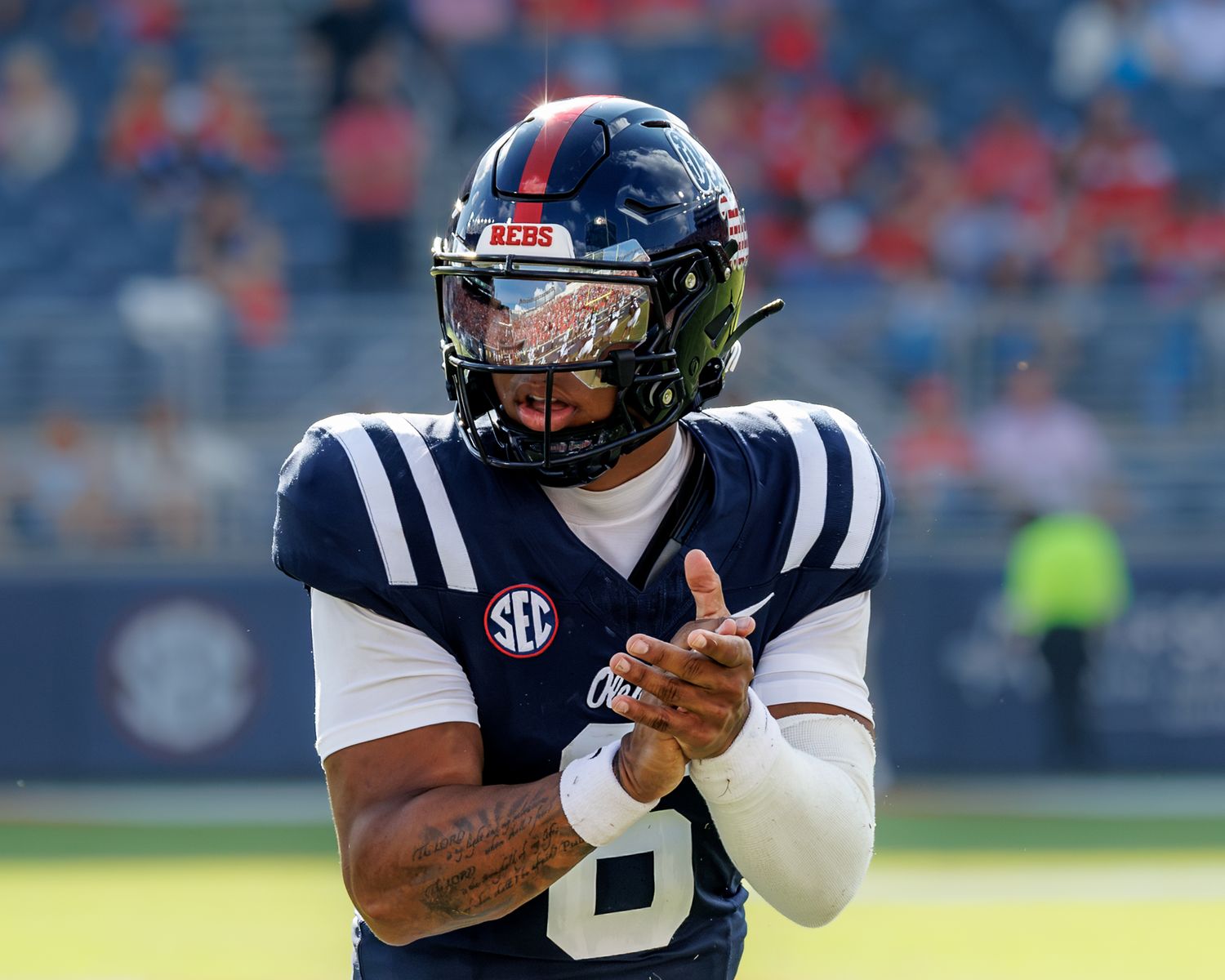 Ole Miss Rebels football player wearing navy SEC uniform number 8 clapping hands during pre-game warmups.