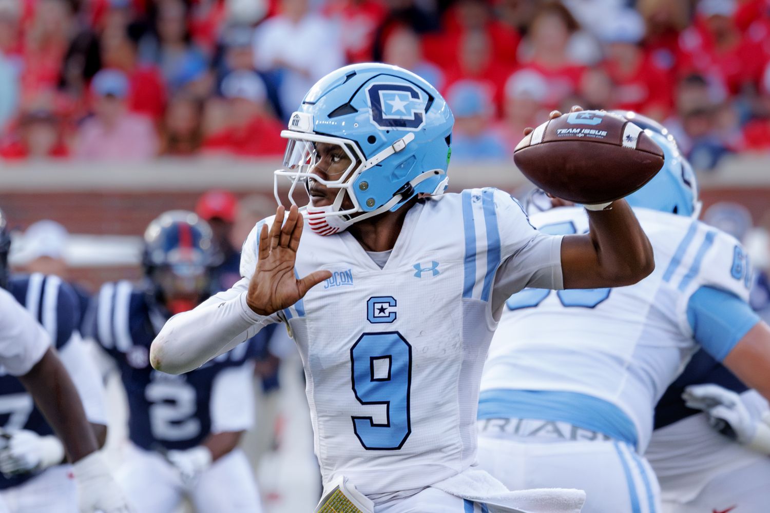 UNC Tar Heels quarterback #9 in light blue jersey throws a pass during a college football game.