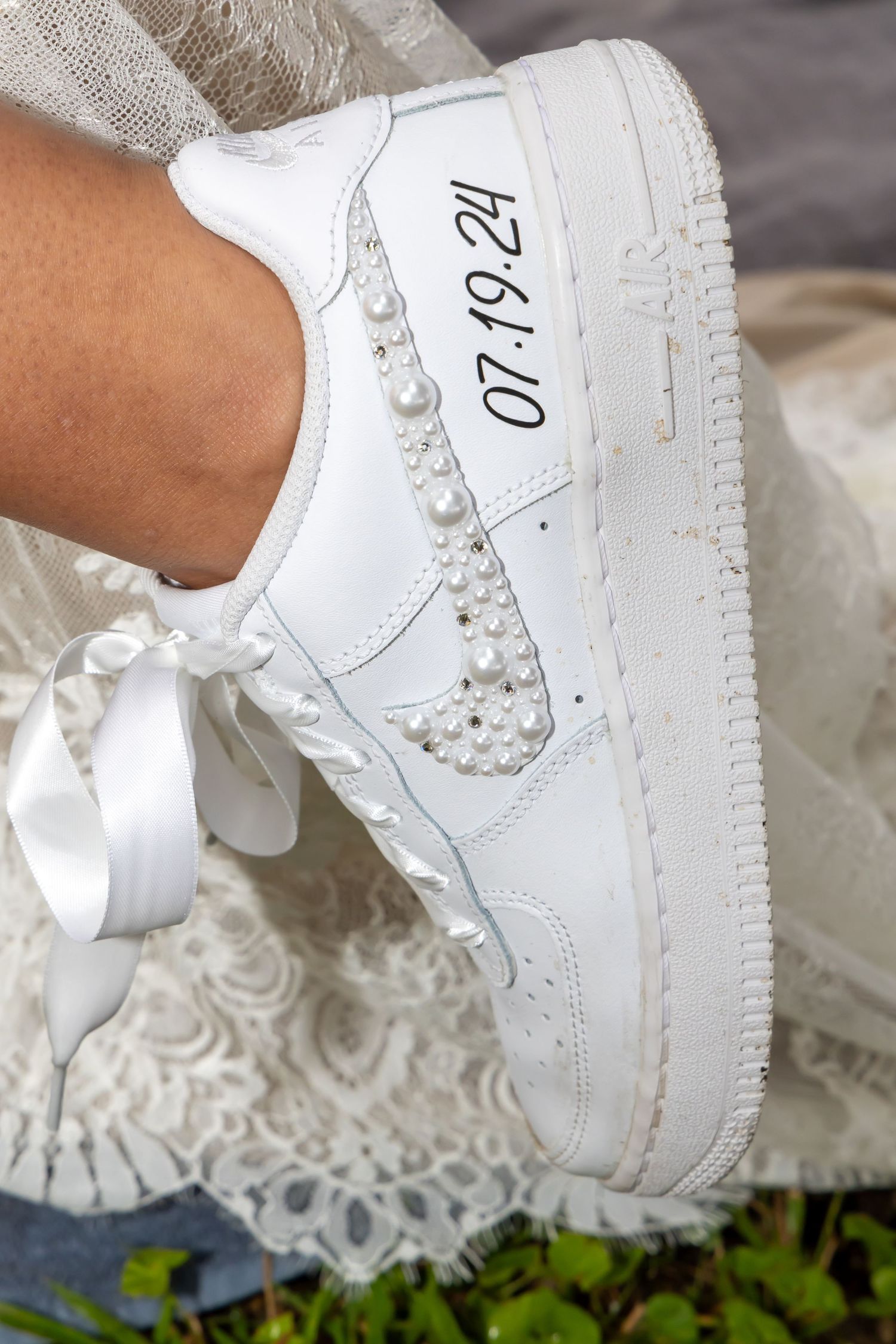 Custom white Nike Air Force 1 sneaker decorated with pearls and wedding date.
