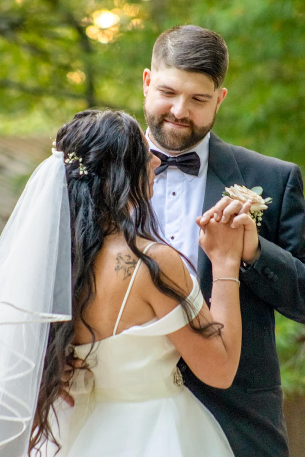 A romantic wedding dance moment captured in soft natural lighting with bokeh effects in the background.