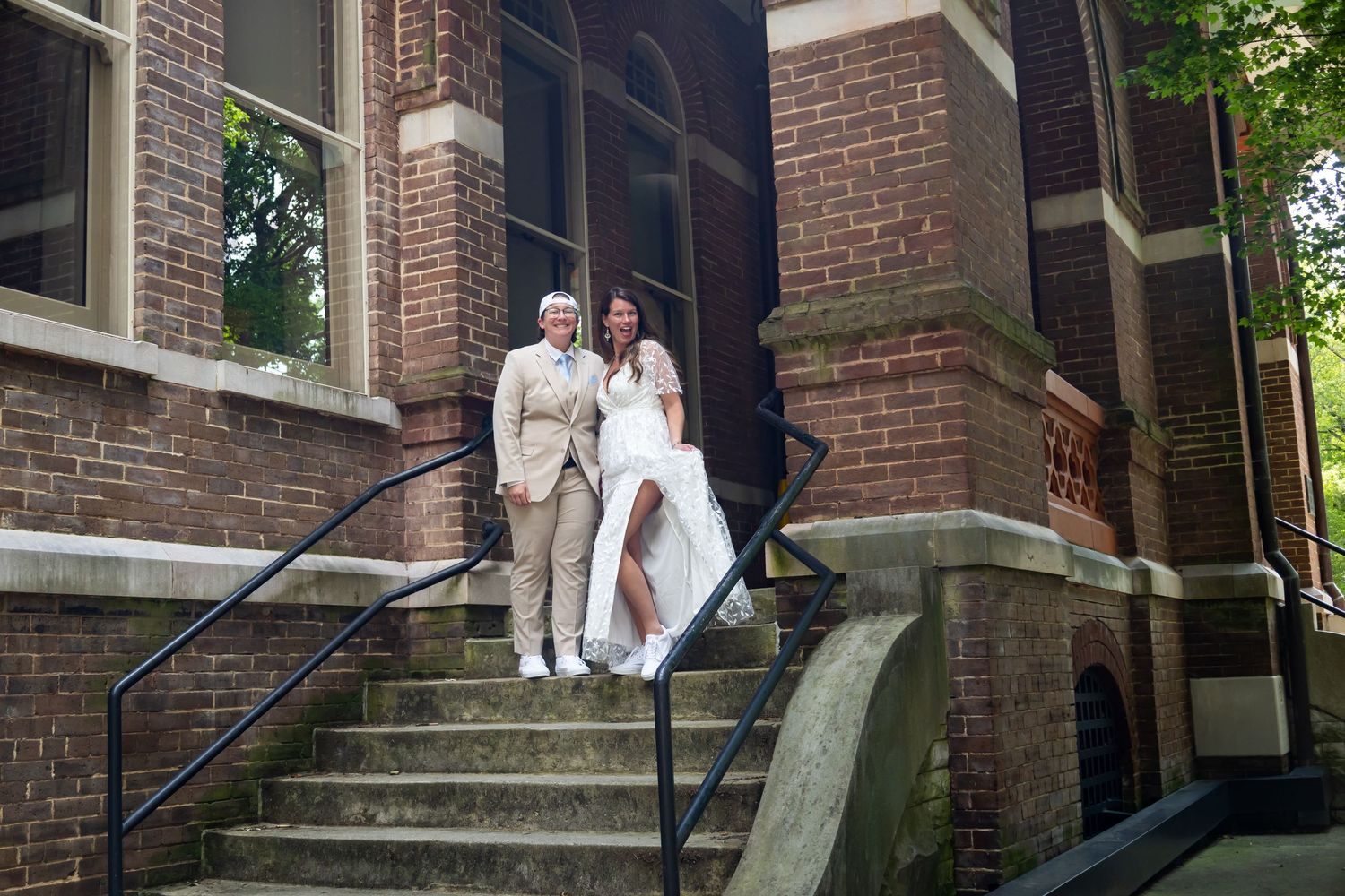 People walking up and down red brick steps of historic building entrance in formal attire.