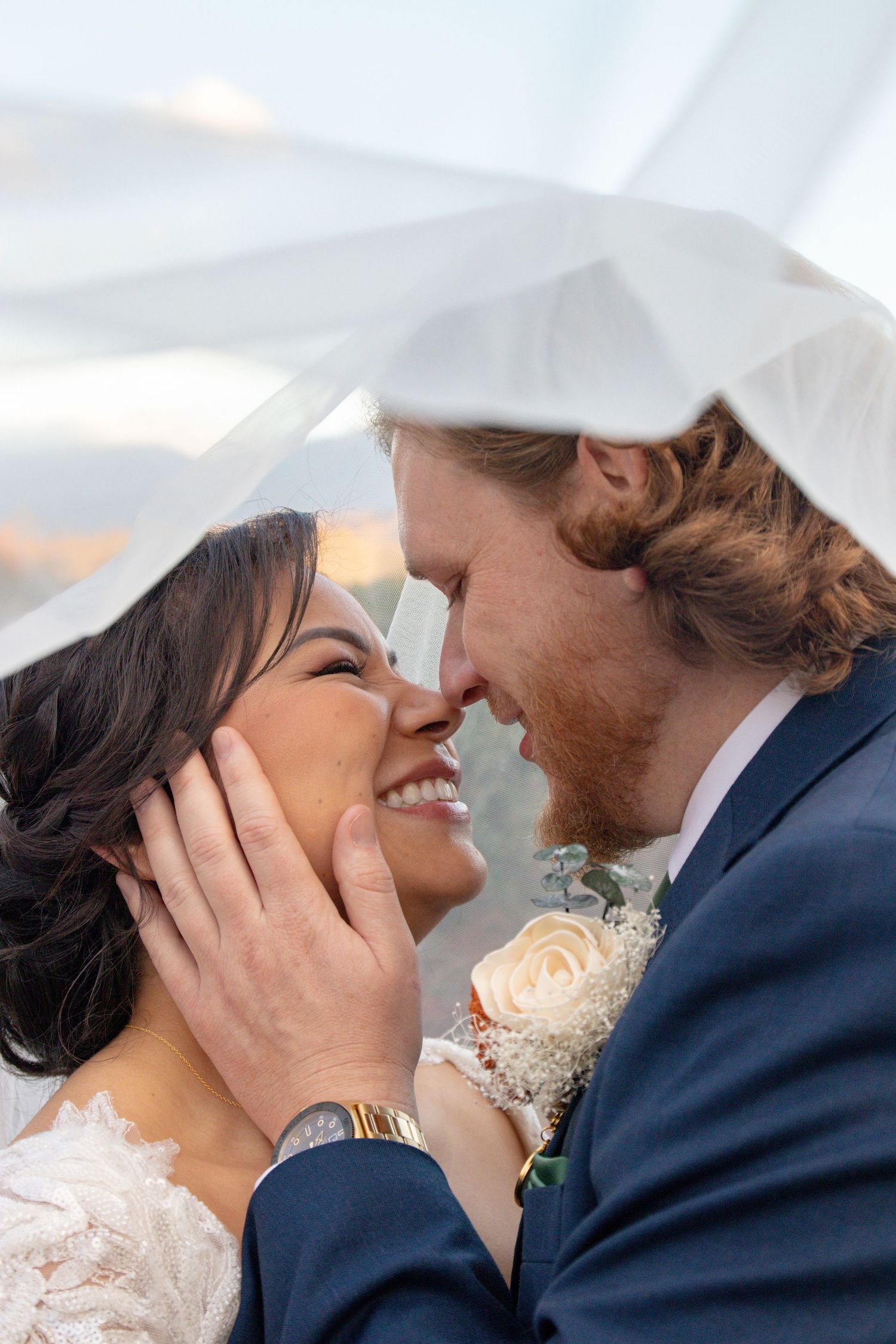 Intimate moment between newlyweds as they share a loving close-up embrace at sunset.