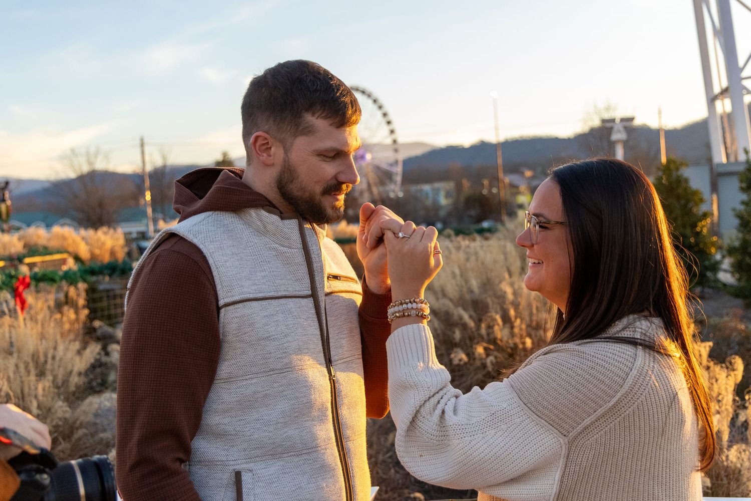 Couple sharing an intimate moment during golden hour in a desert landscape with mountains in background.