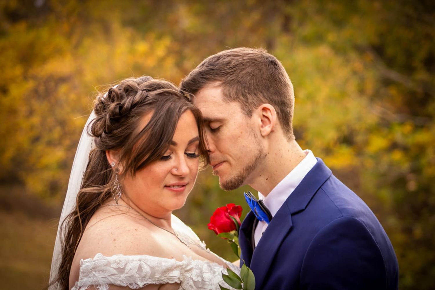 An intimate moment captured between newlyweds against a warm autumn background.