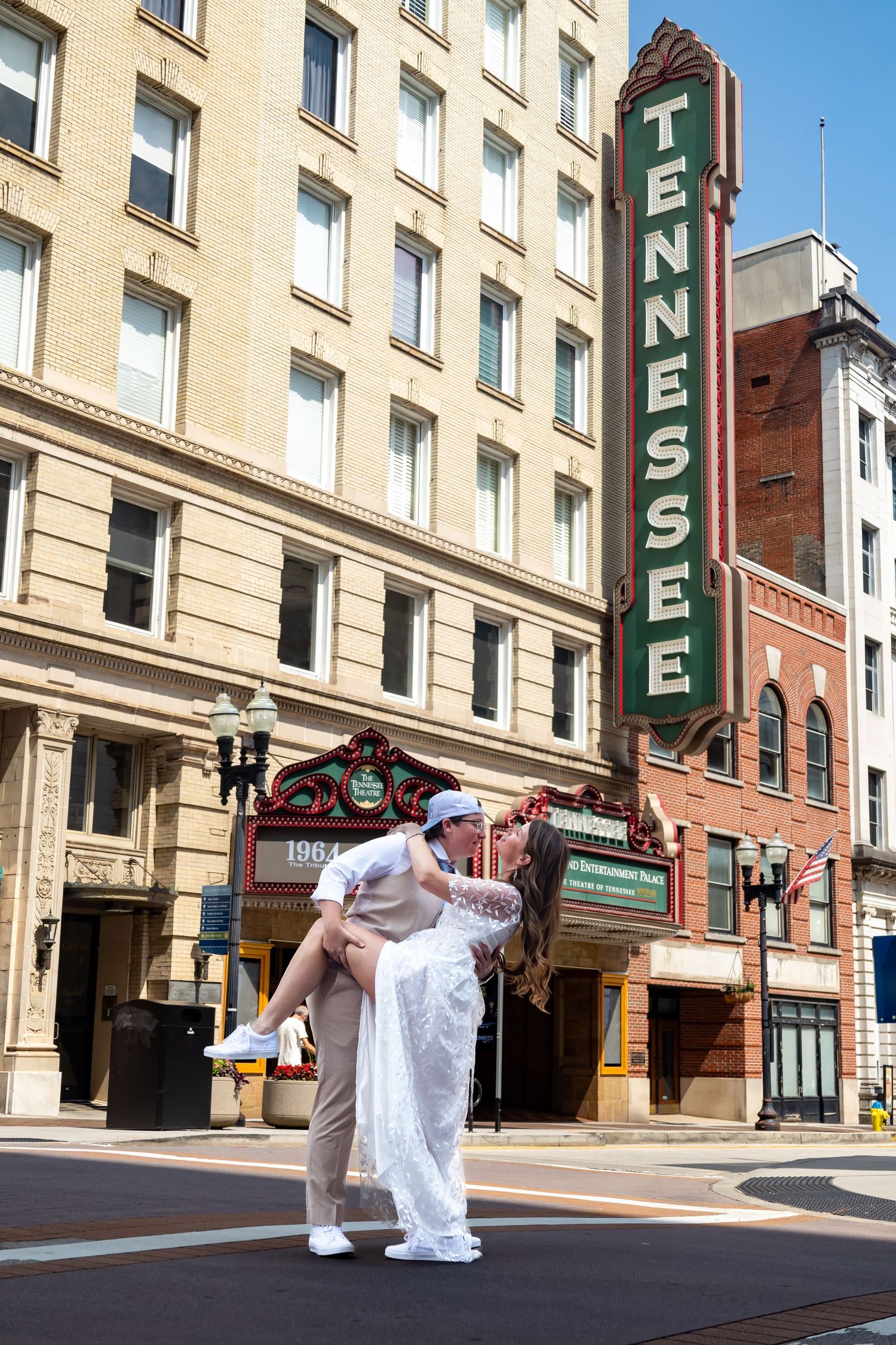 Dancing couple poses in front of historic Tennessee Theatre's iconic vertical sign in downtown Knoxville.