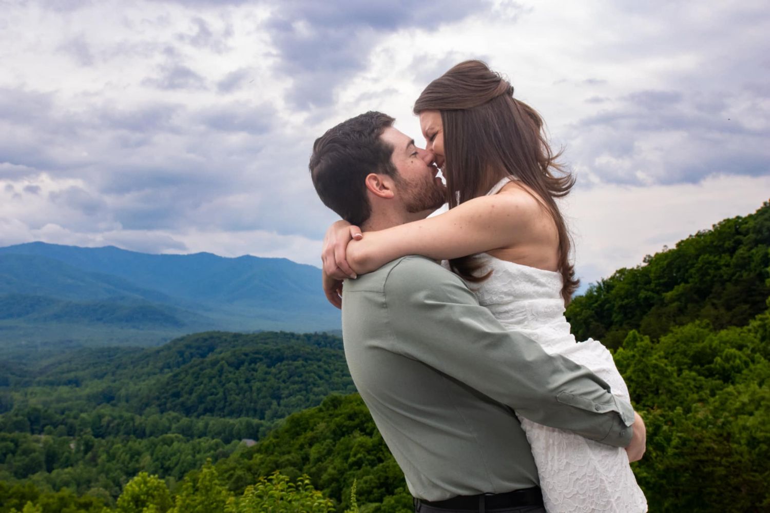 A romantic mountain vista serves as backdrop for an intimate wedding moment at sunset.