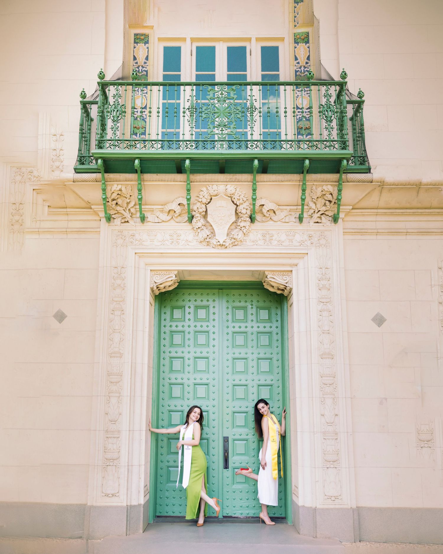 Art deco doorway with ornate green balcony and decorative stonework at historic building entrance.