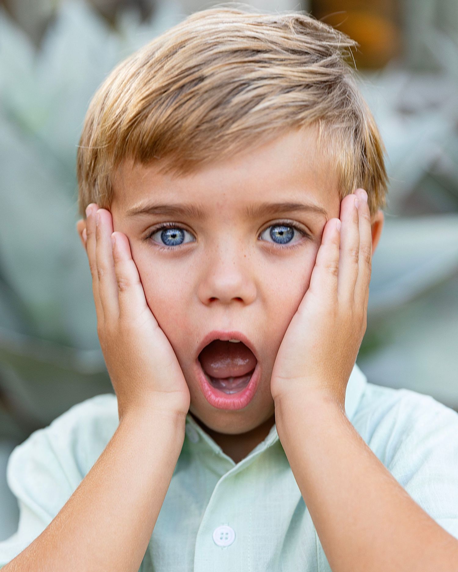 A young boy, with his mouth wide open and his hands on his face ala Home Alone.