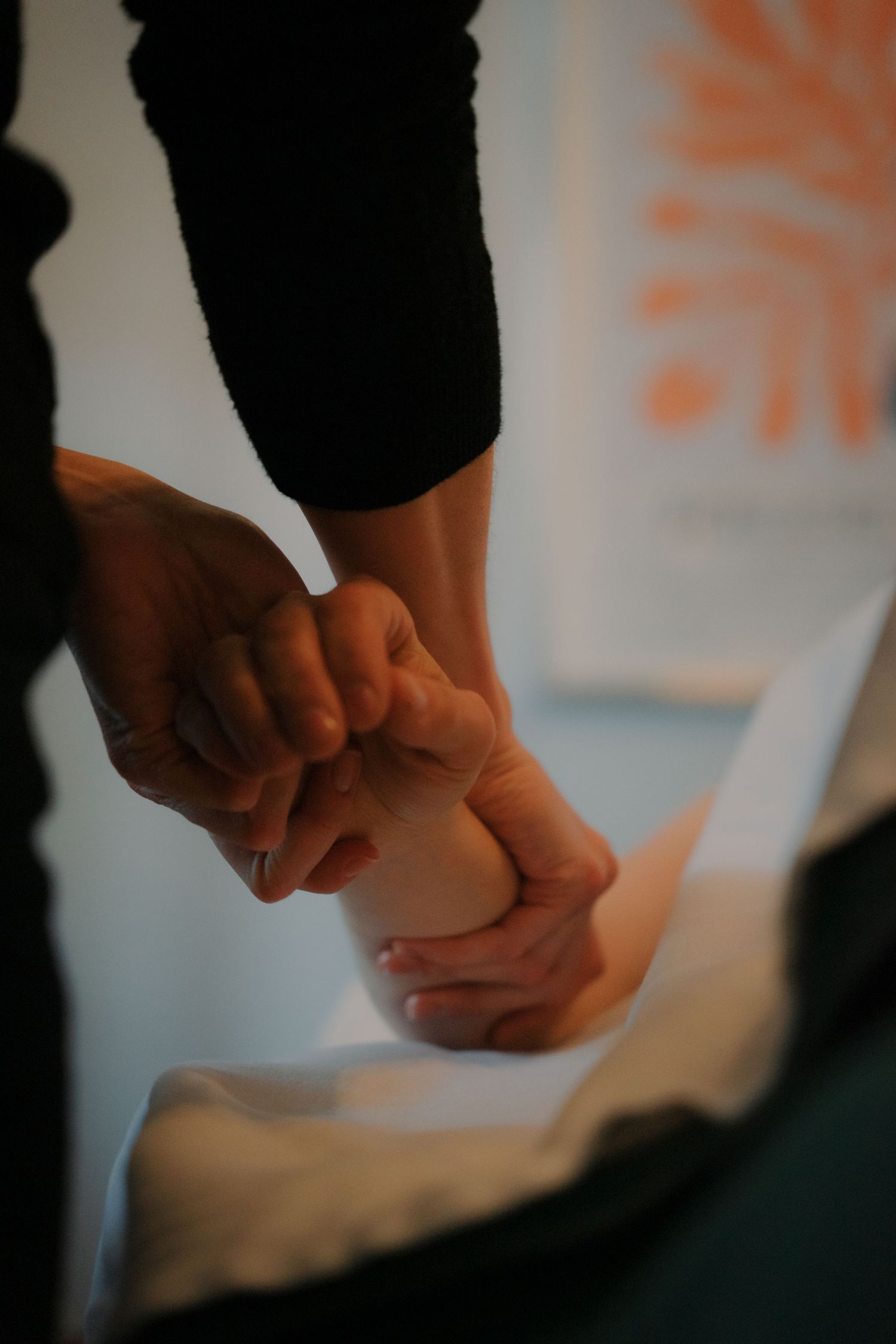Therapist performing a professional hand and wrist massage treatment on a client.