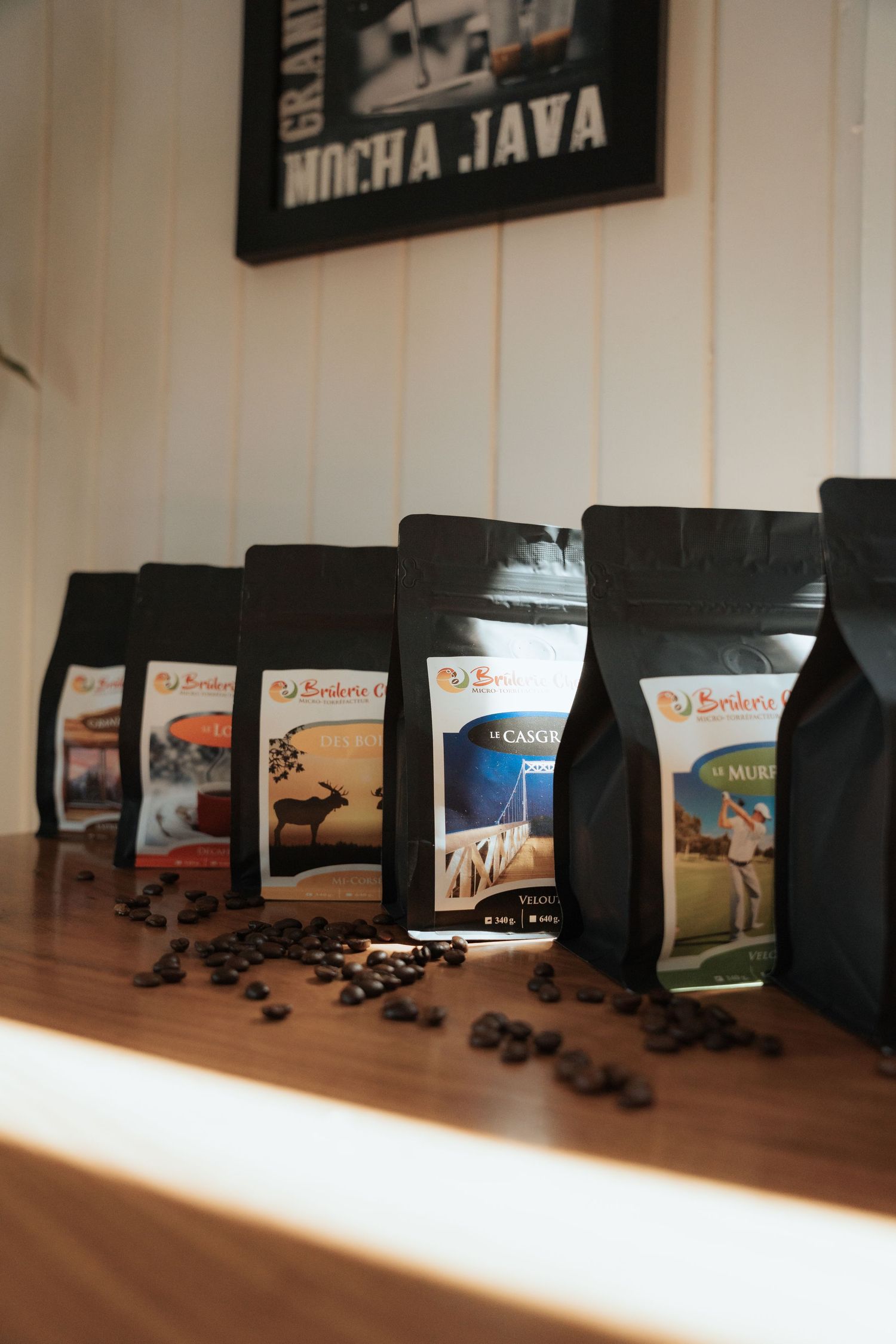 Row of Brokru branded coffee bags displayed on a wooden shelf under a Mocha Java sign.