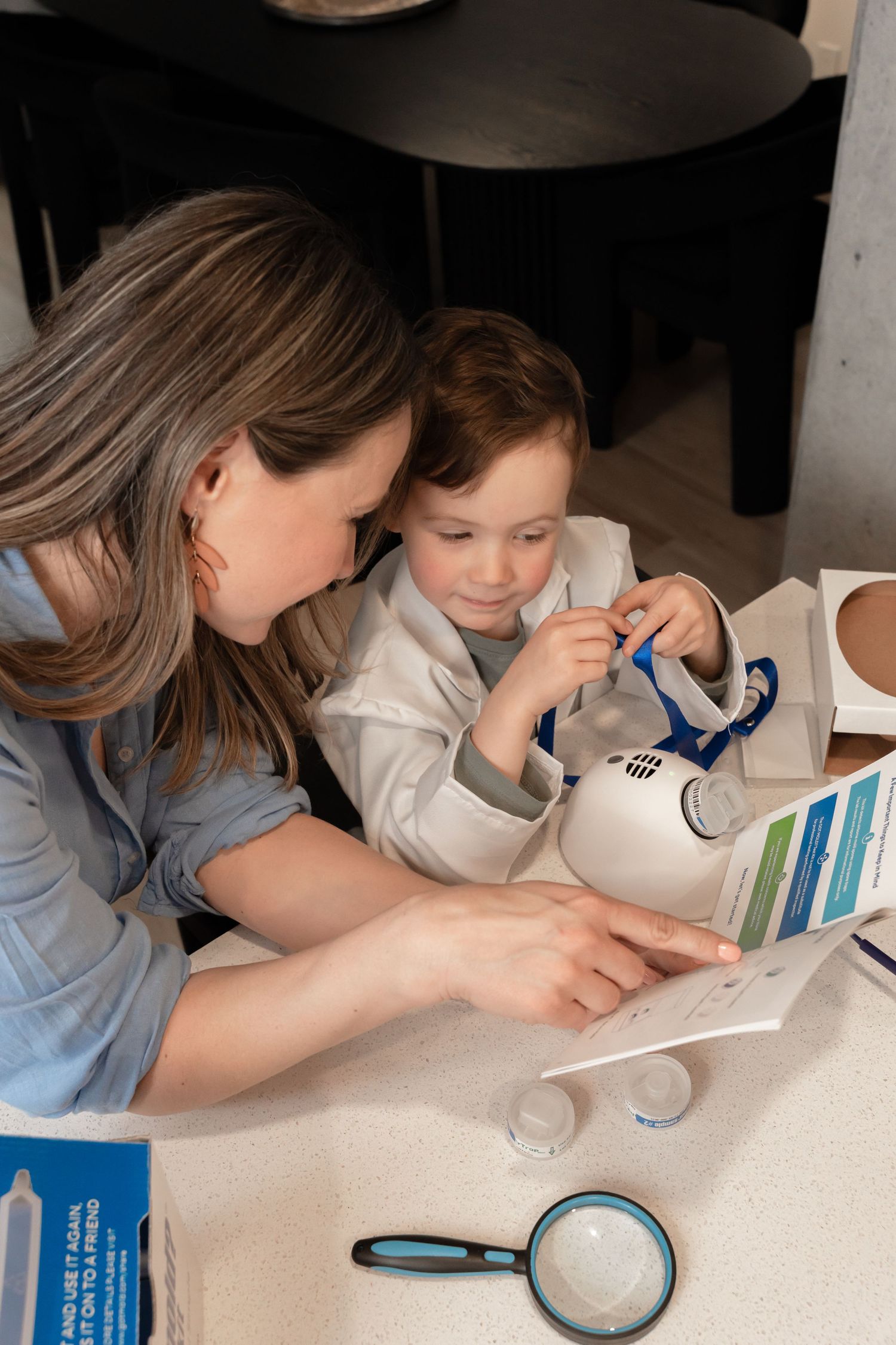 Mother and son reading instructions for Got Mold home test kit together at kitchen counter.