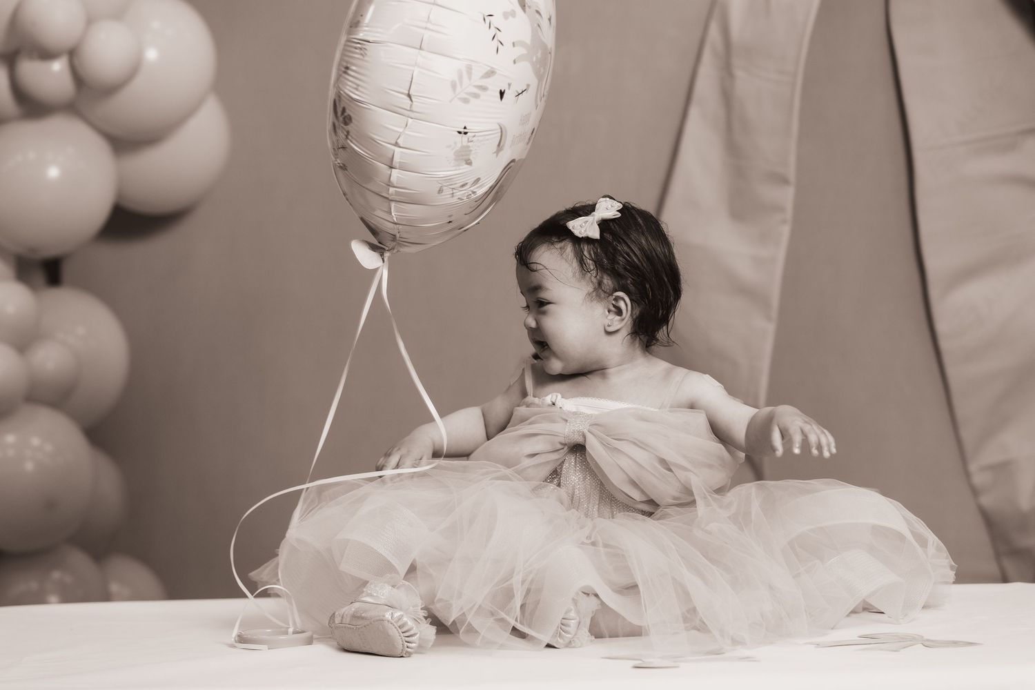 Black and white portrait series with white balloons and soft lighting.