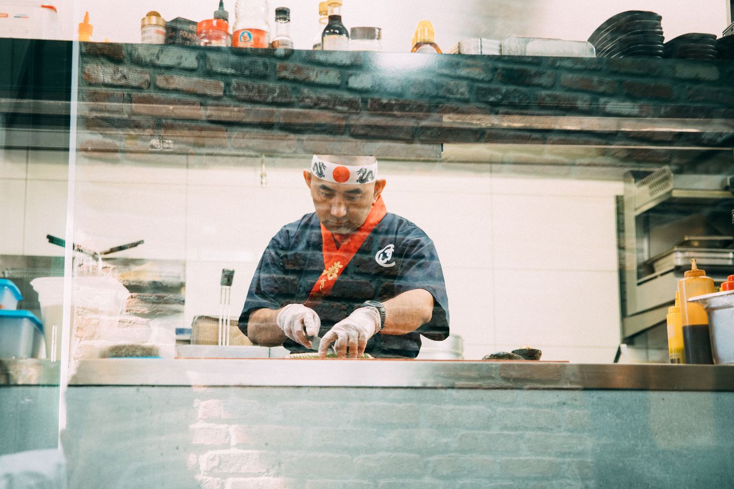 View through kitchen service window showing food preparation area in restaurant.