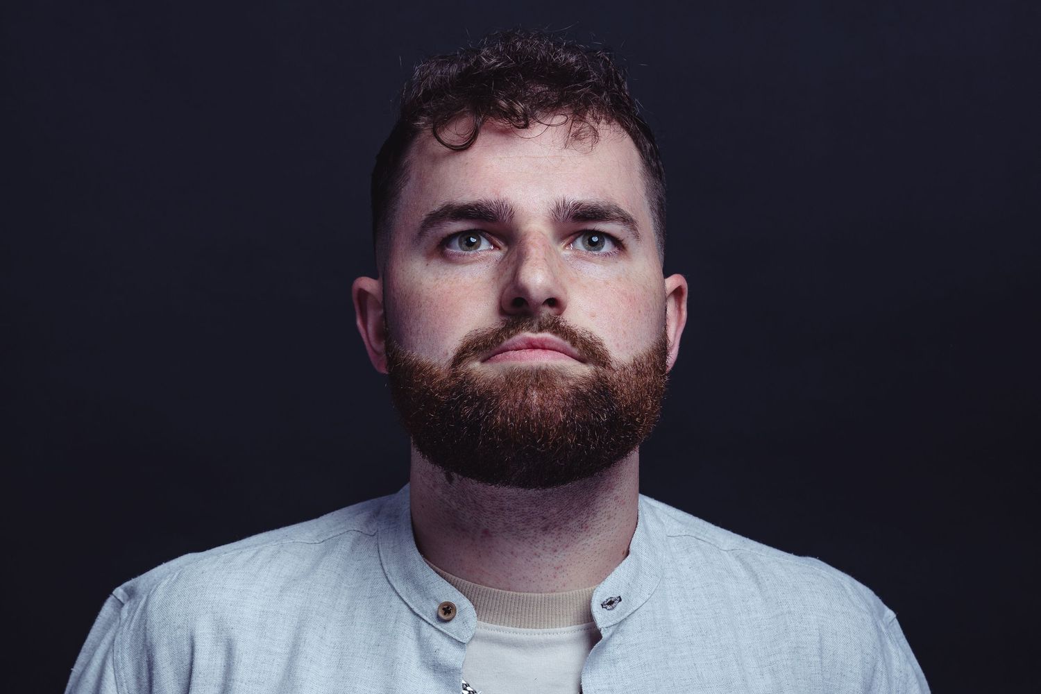 Portrait series of person in dramatic lighting against dark background.