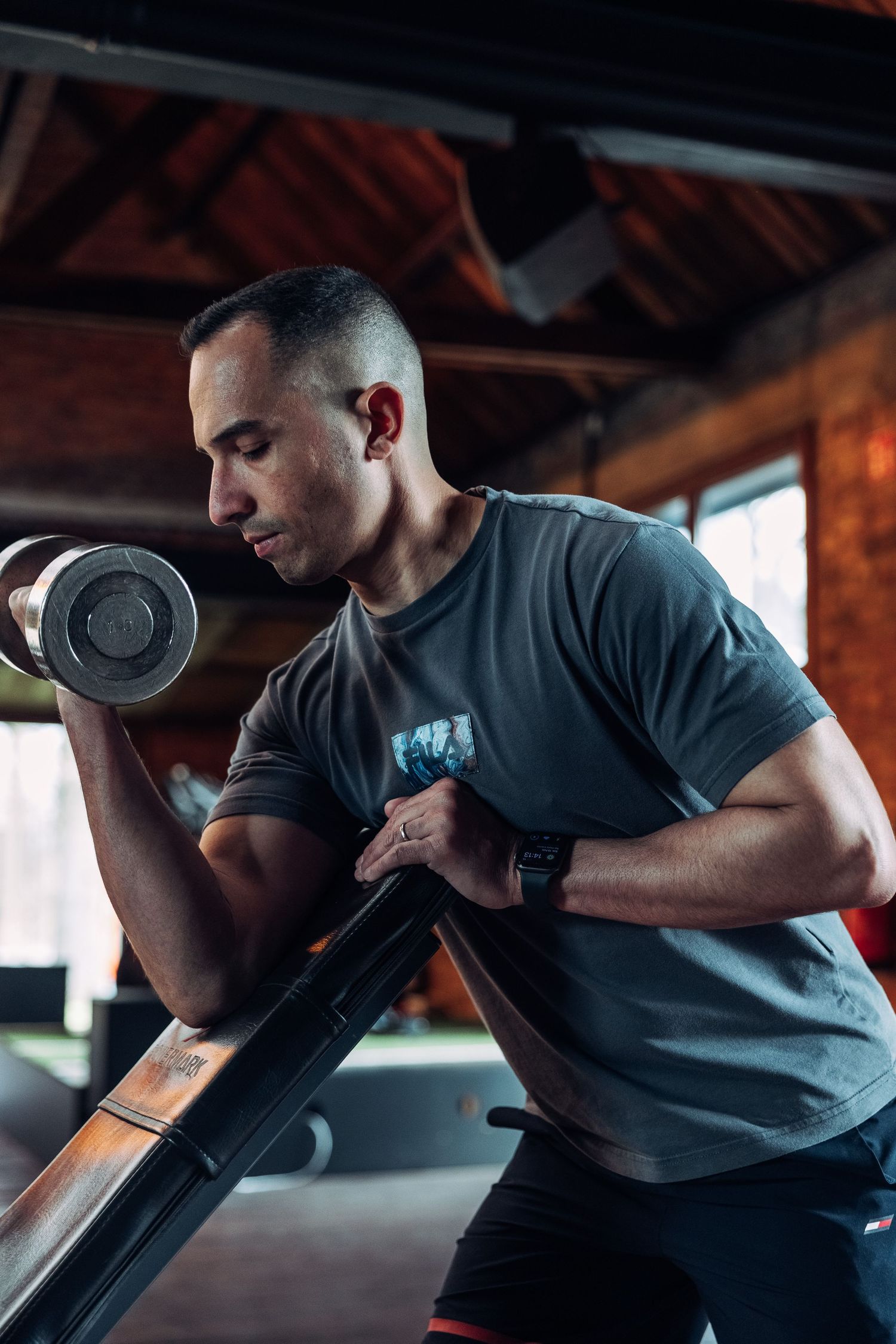 Person performing dumbbell exercises in a modern industrial gym setting.