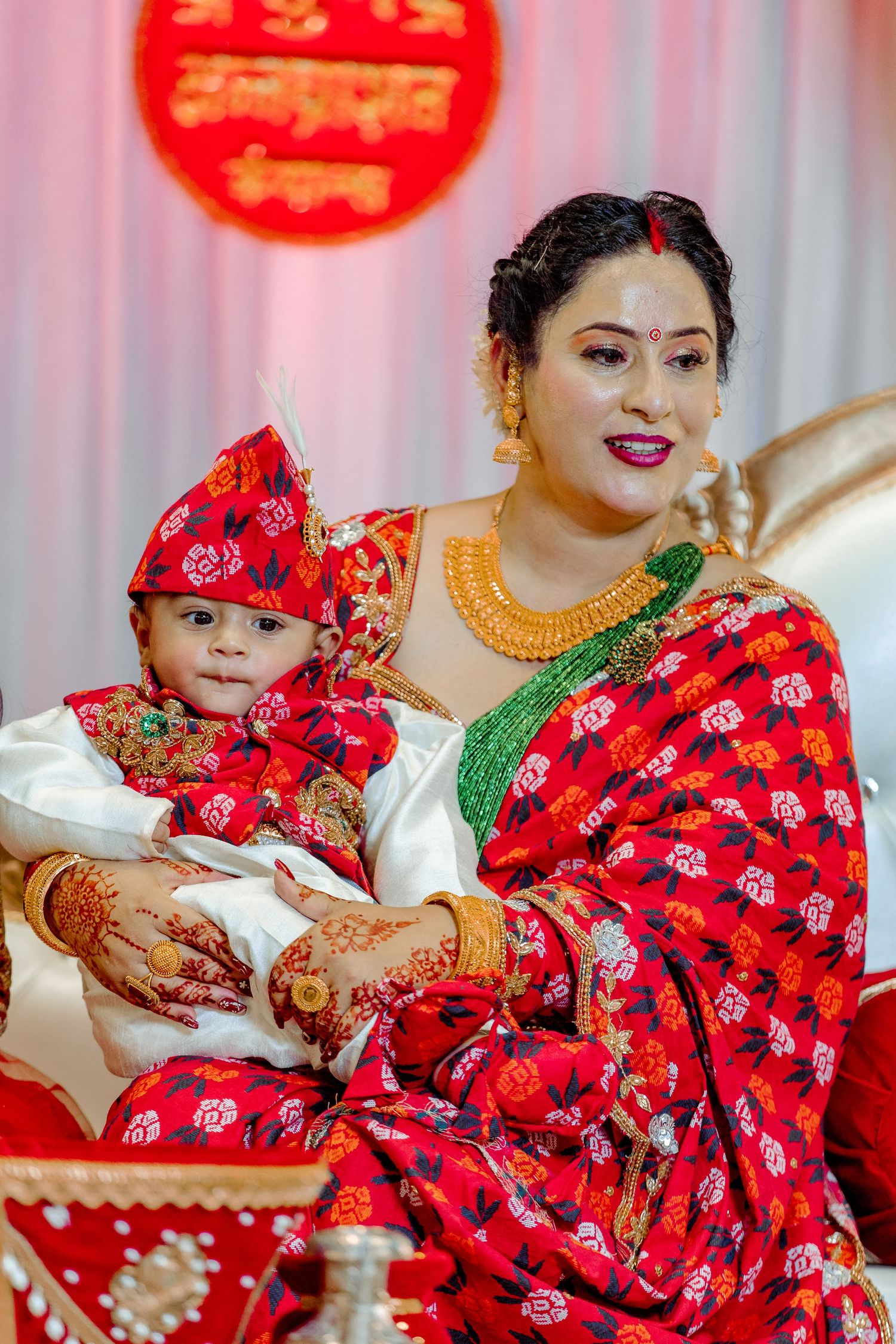 Traditional Nepali cultural celebration with red and gold decorative elements.
