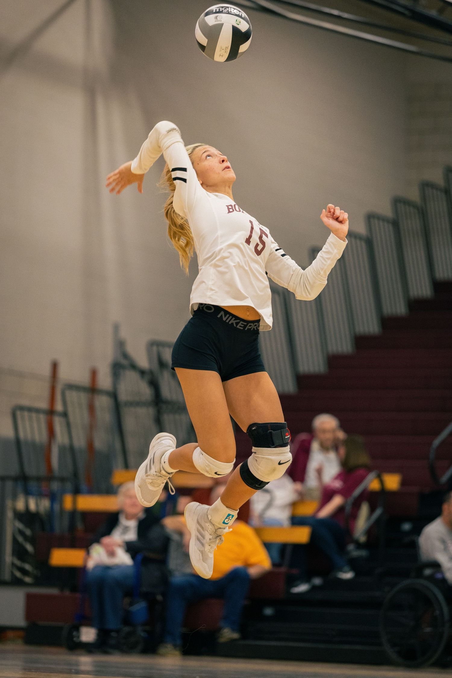 Volleyball player leaping to make defensive play during match.