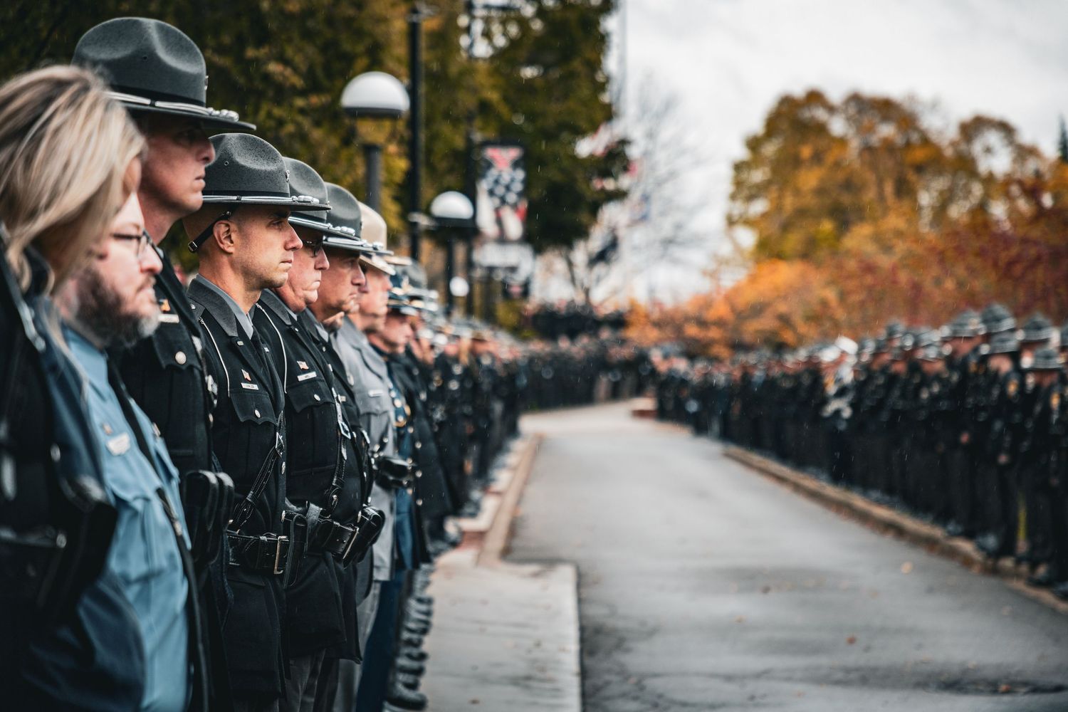 A long line of uniformed officers stand at attention during a ceremonial event.