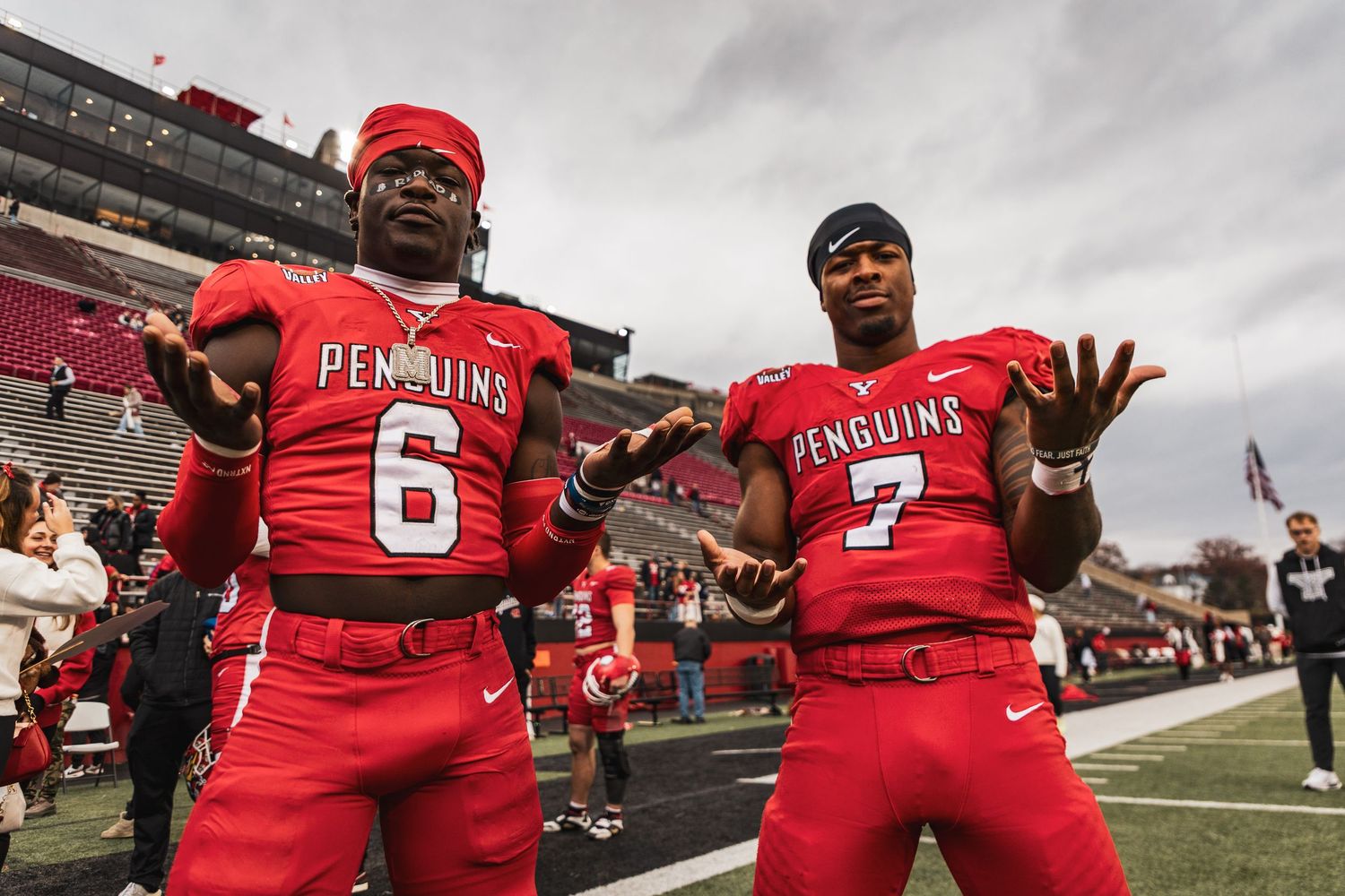 Athletes in red uniforms 6 7 celebrate on a football field.