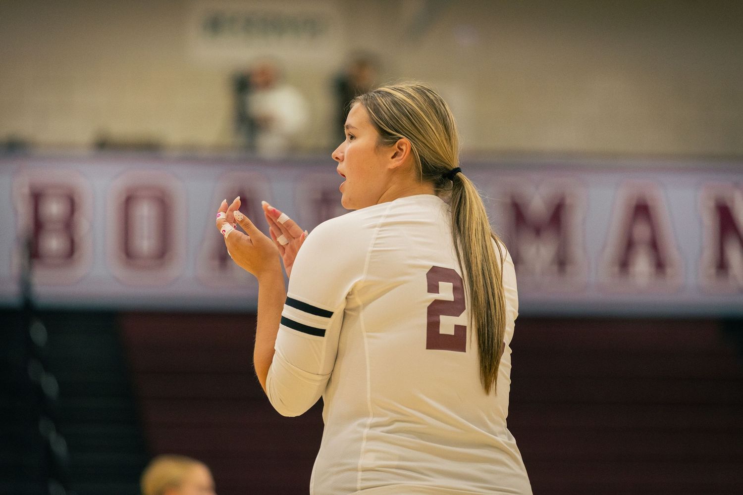 Side view of volleyball players in action during indoor game.