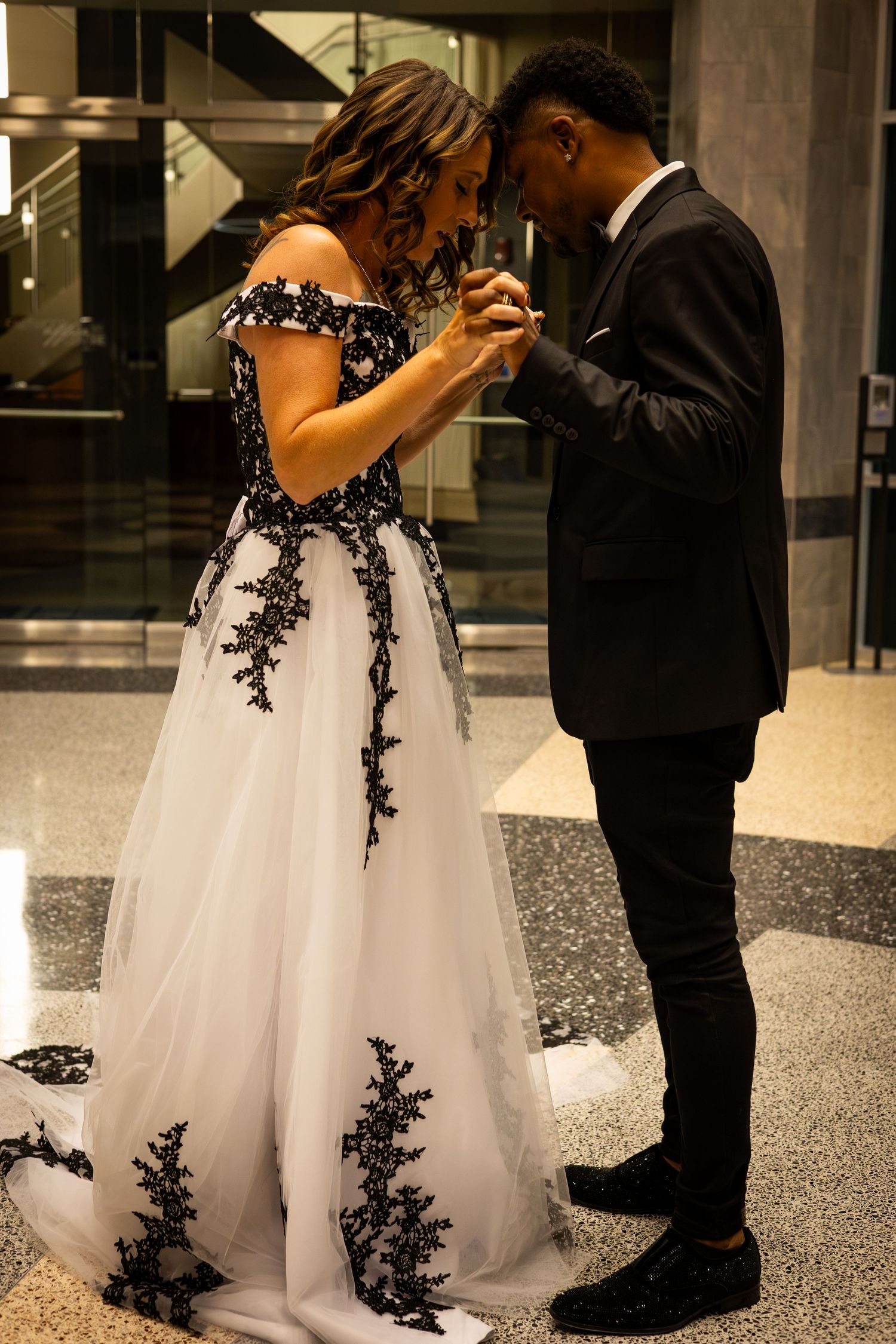 Couple in formal attire sharing an intimate moment at an elegant venue.