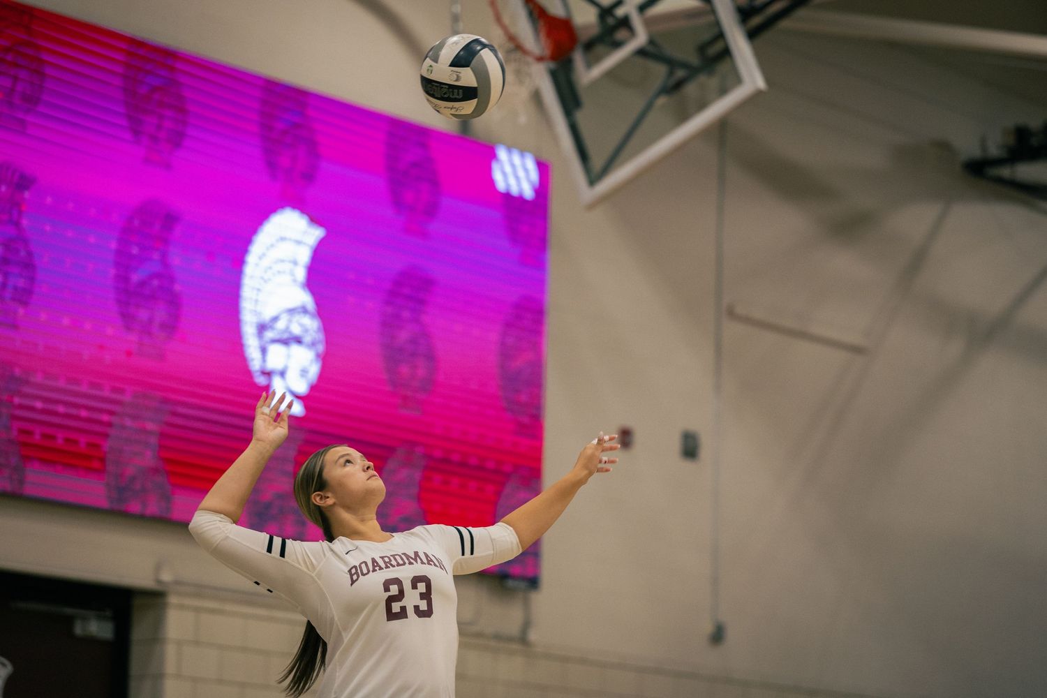 Volleyball match with bright pink lighting illuminating the court.