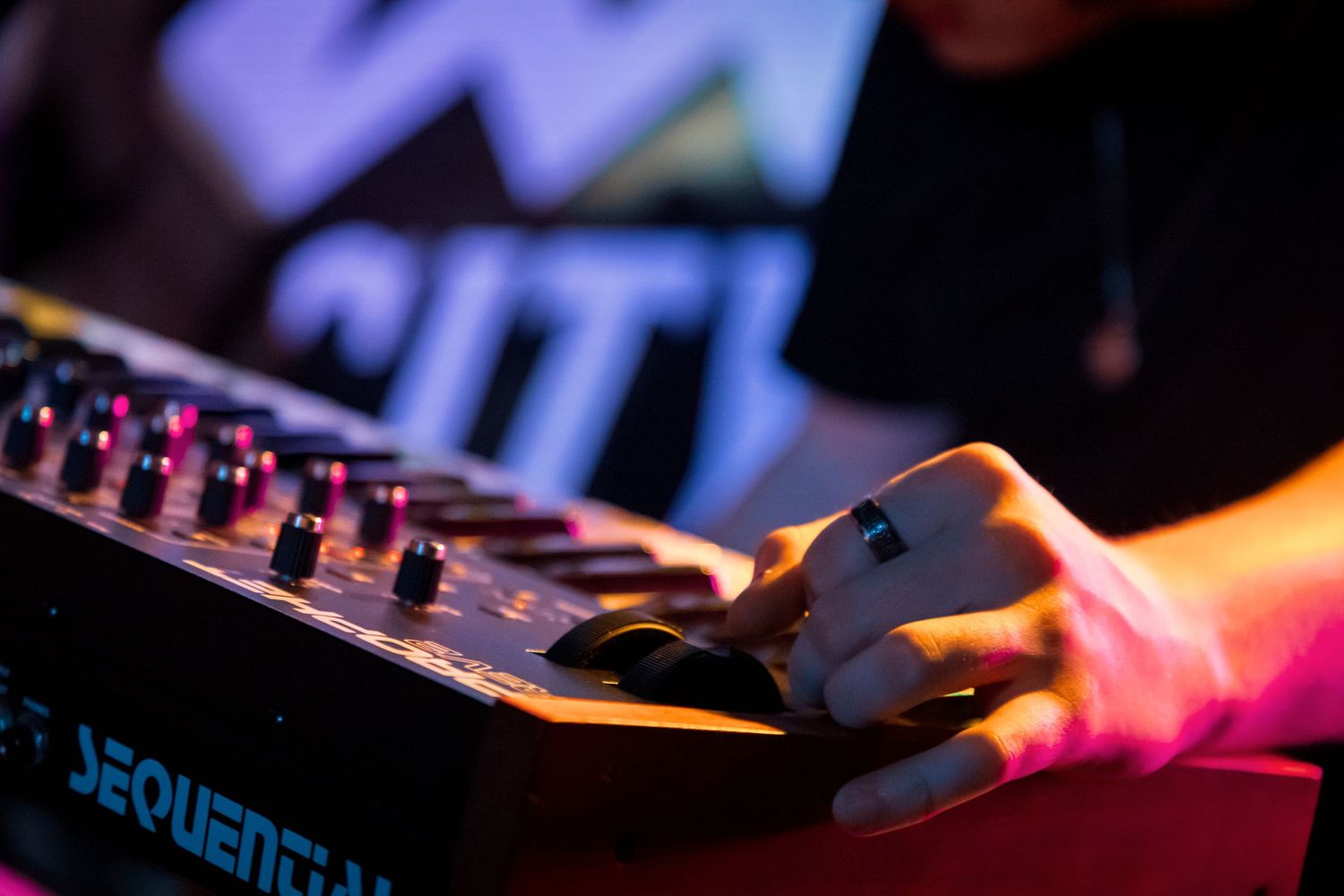 Close-up of illuminated DJ equipment and control panels in dark lighting.
