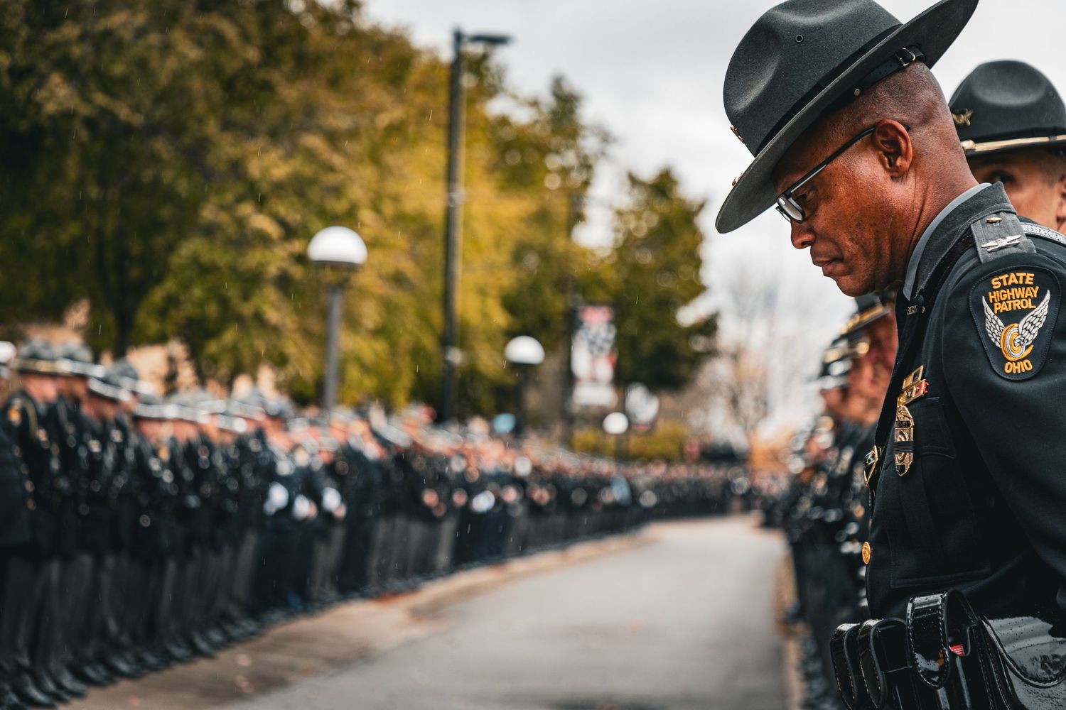 Officers in dress uniforms and campaign hats stand in formation during a ceremony.